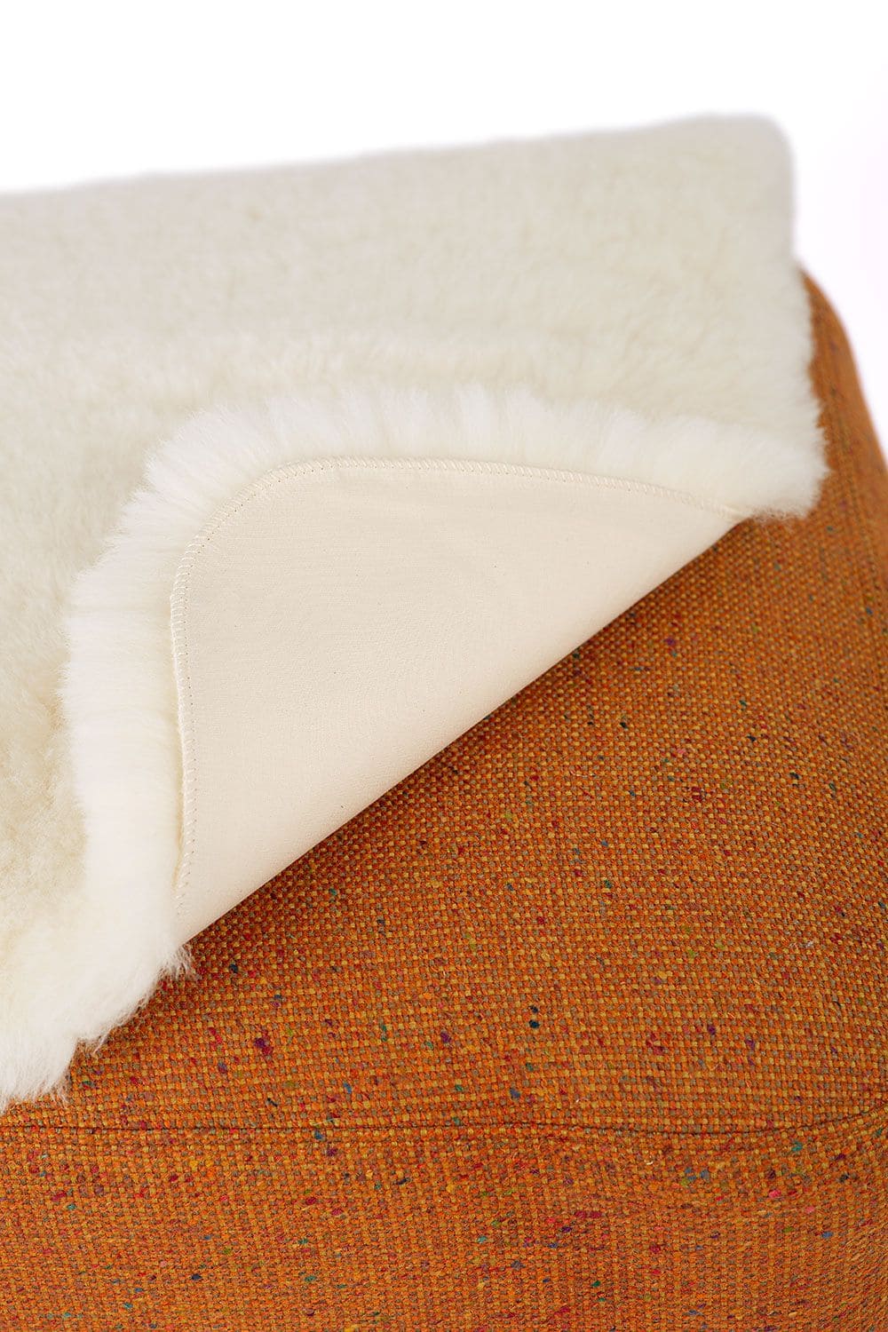 kleine Finkhof Fellauflage mit Bezug aus pflanzlich gegerbtem Schaffell über eine Ecke geklappt von unten