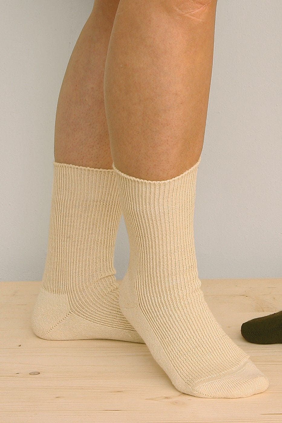 Person trägt dünne naturweiße Wollsocken aus bio Wolle (kbT) und bio Baumwolle (kbA)