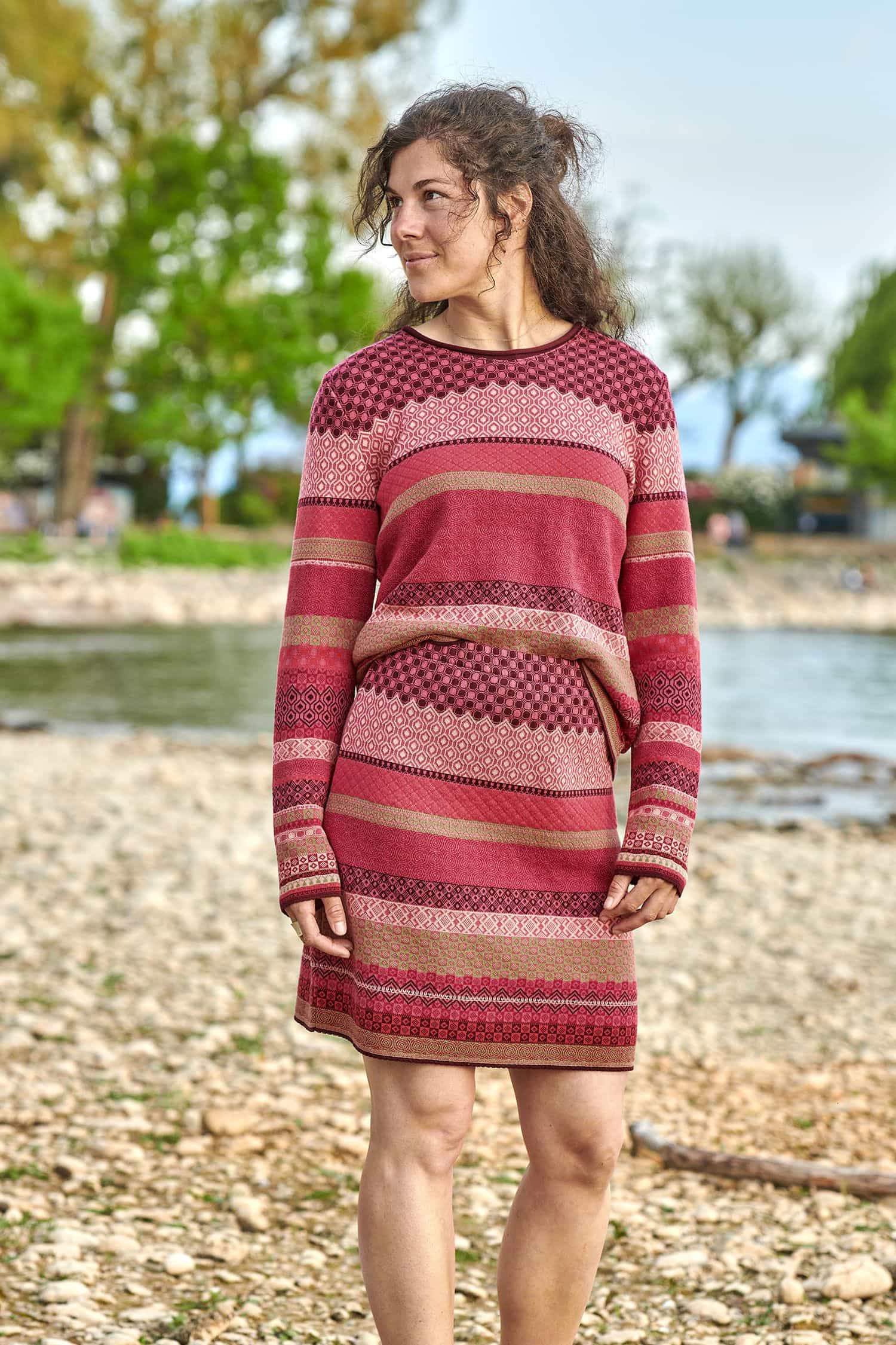 Frau trägt gemusterten Rock und Pulli in beere und pink aus bio Baumwolle (kbA)