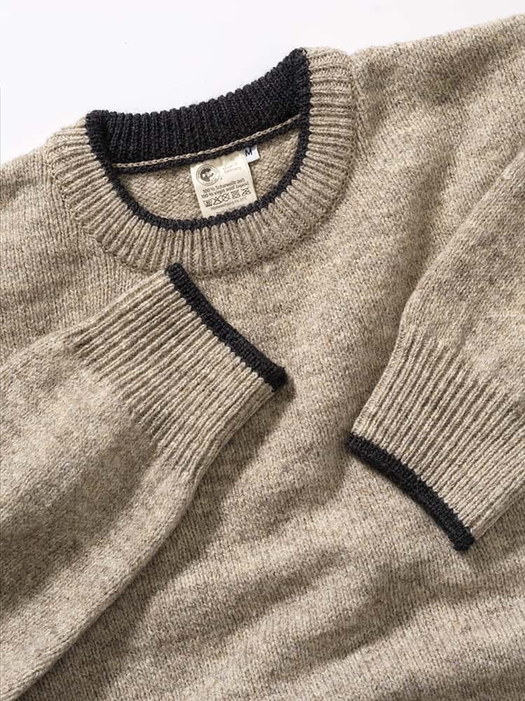 Kragen und Ärmelbündchen des grauen ungefärbten Finkhof Pullis aus bio Wolle (kbT)