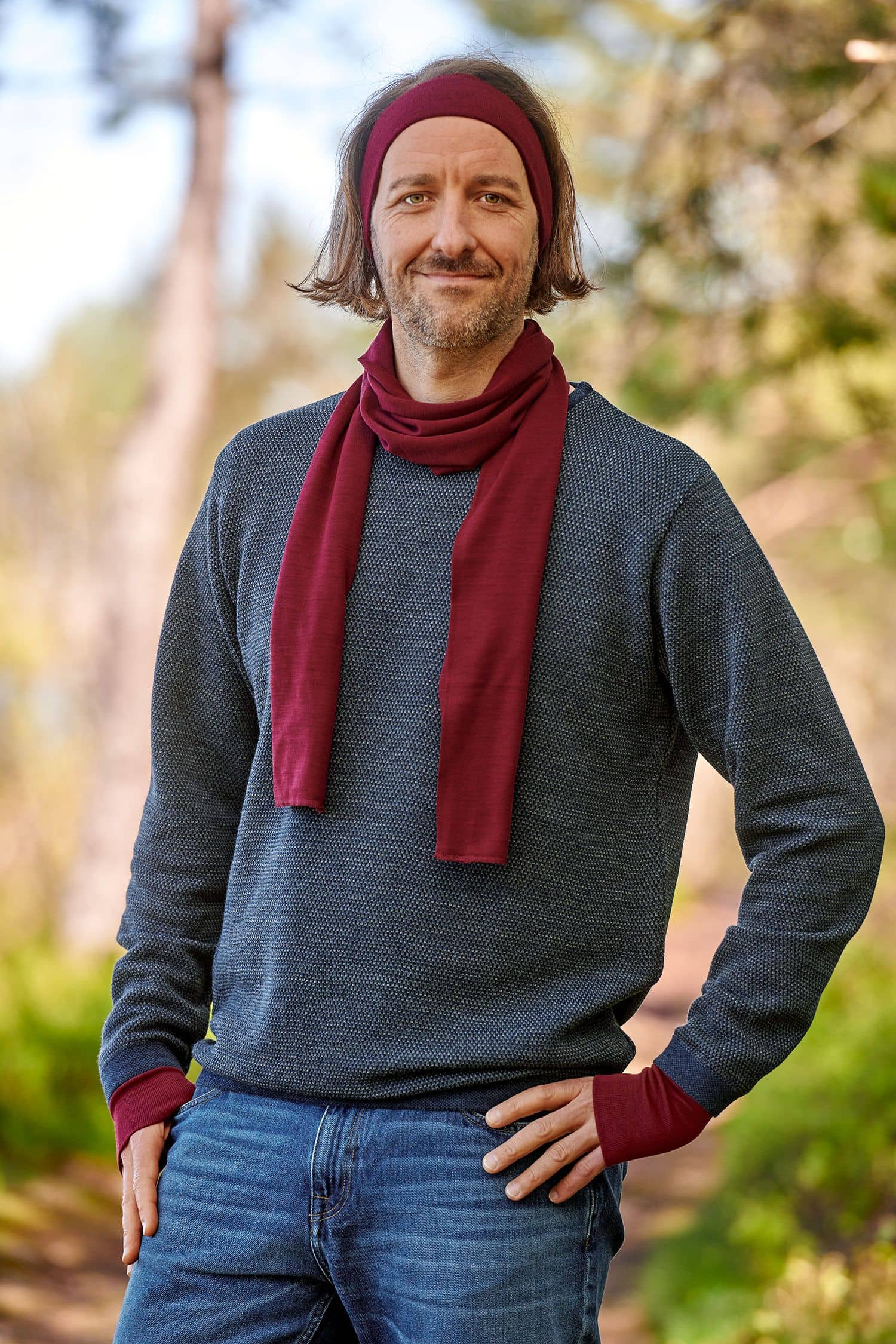 Mann mit grauem Pulli trägt ein bordeauxrotes Stirnband aus bio Wolle (kbT) und Seide mit passendem Schal