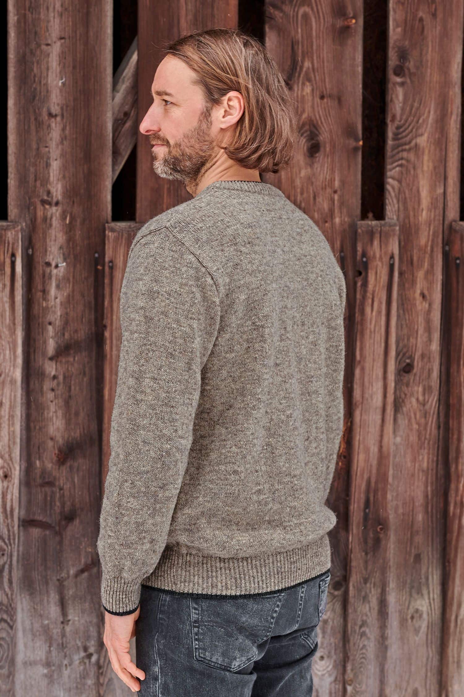 Rückansicht von Mann mit braunem Finkhof Pulli aus bio Wolle (kbT)