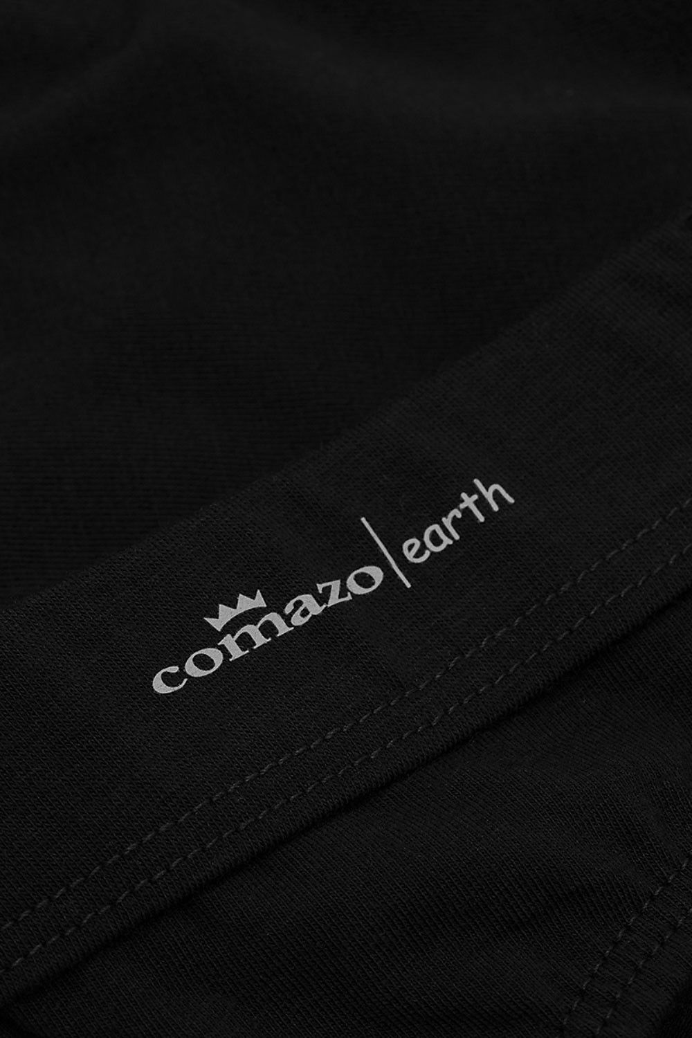 Detailaufnahme vom Druck des Firmennamens auf schwarzer Unterhose aus bio Baumwolle (kbA) und Elasthan