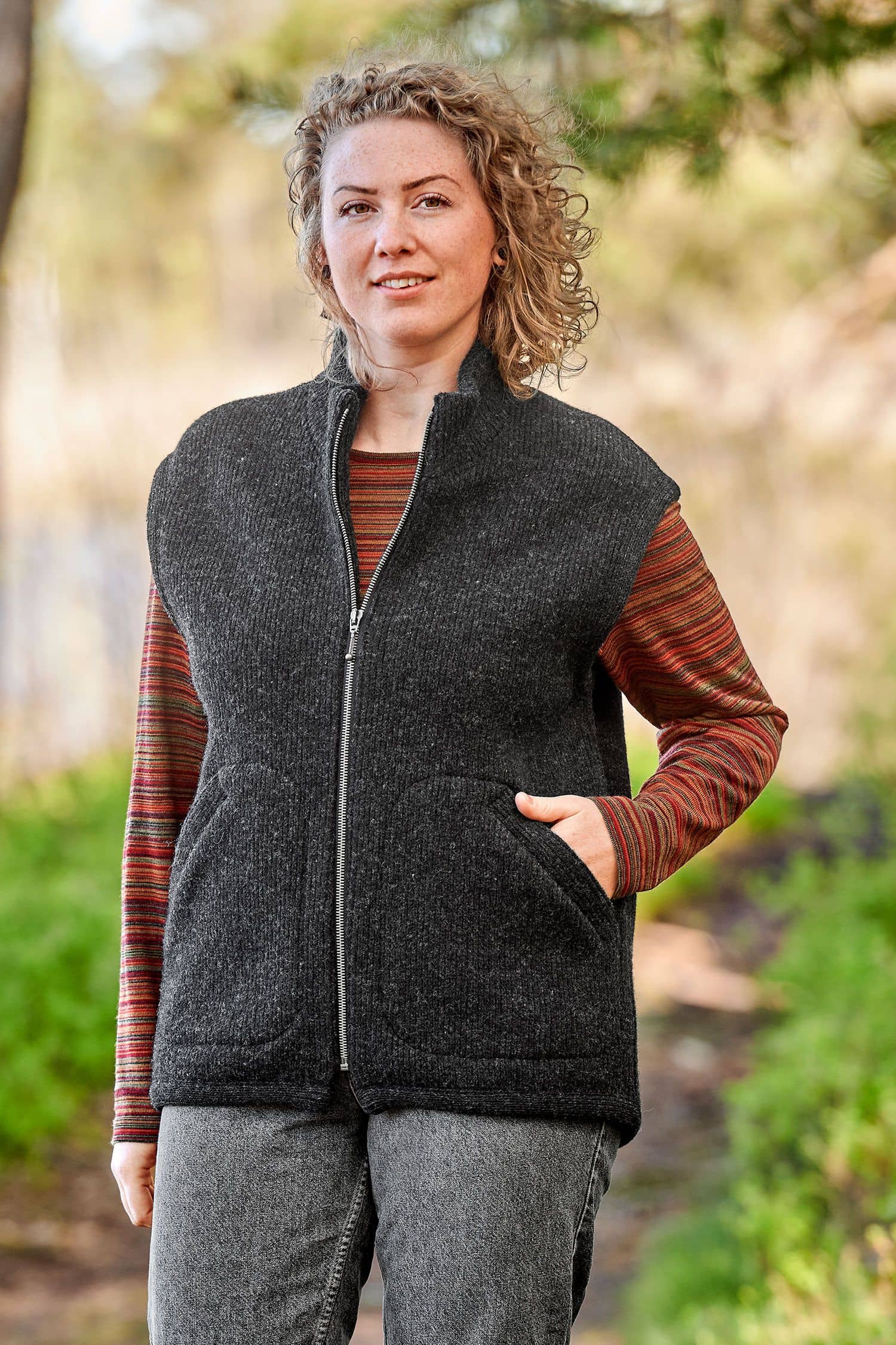 Finkhof-Wollwalkweste gefärbt anthrazit Gr. S Frau mit rotem Streifenshirt trägt anthrazitfarbene Wollwalkweste aus bio Wolle (kbT) ohne Ärmel vom Finkhof