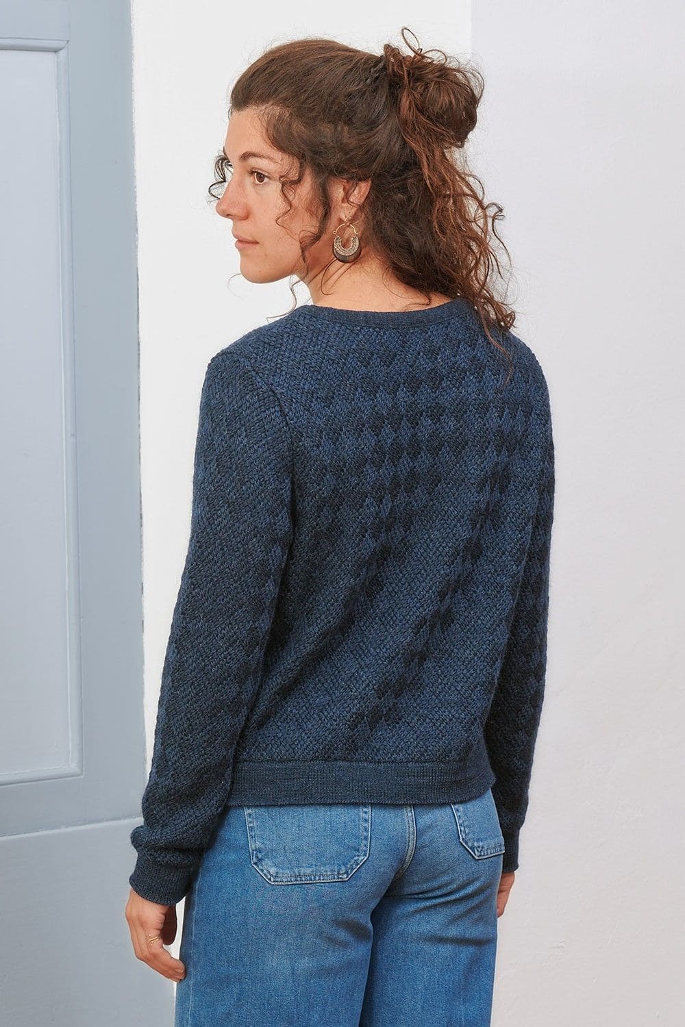 Rückansicht von Frau mit blauem Pullover aus bio Wolle (kbT)