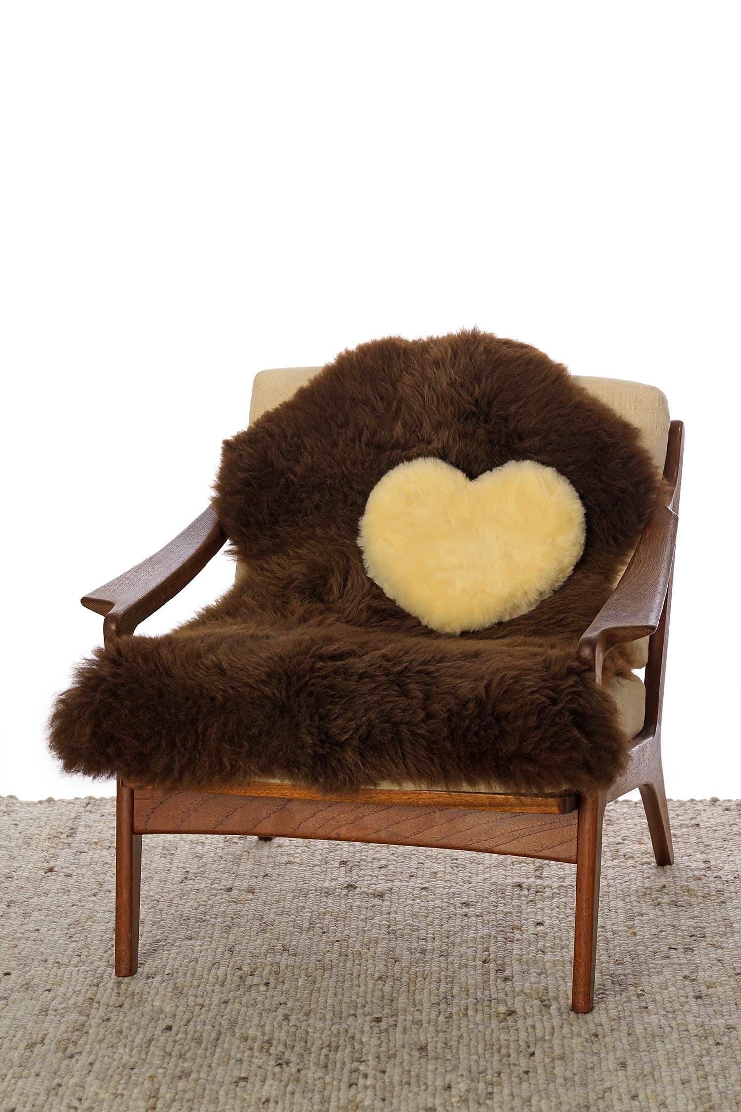 gelbliches relugan gegerbtes Herzkissen aus Finkhof Schaffell auf braunem Fell und Sessel