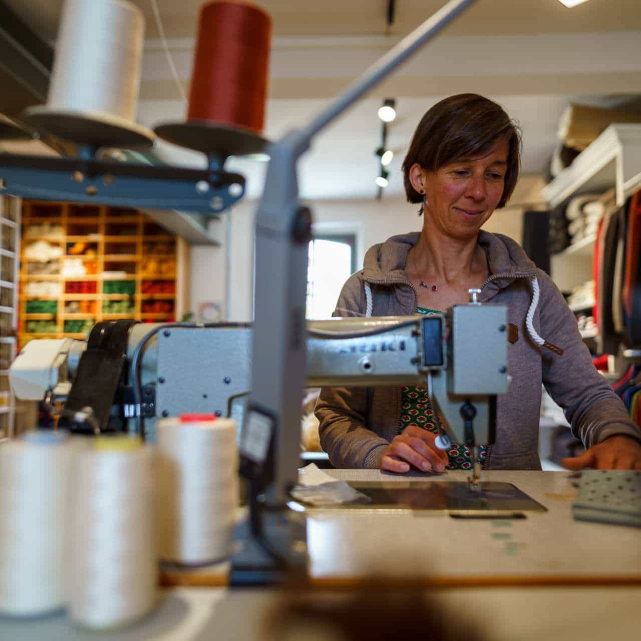 Frau näht an einer Nähmaschine