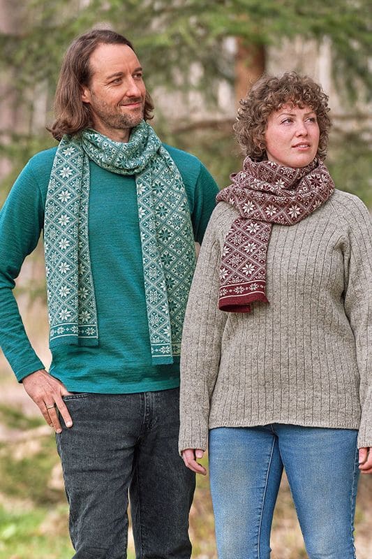 Schal Svea Frau und Mann tragen Wollpullis und Schal mit winterlichem Muster in burgunder und türkis aus bio Wolle (kbT)
