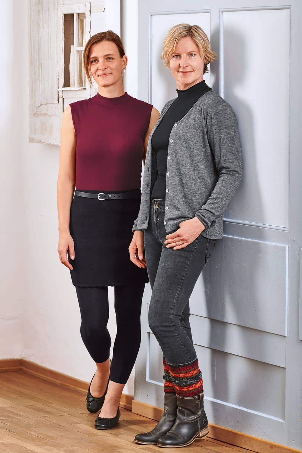 Stehkragentop Stehkragentop aus bio Wolle (kbT) und Seide in bordeaux und schwarz getragen von Frauen mit schwarzer Kleidung vor Tür