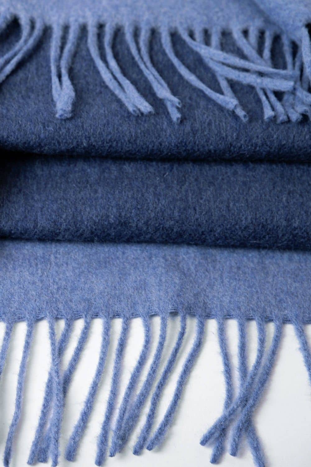 Nahaufnahme von blauem Reiseplaid mit Fransen aus bio Wolle (kbT)