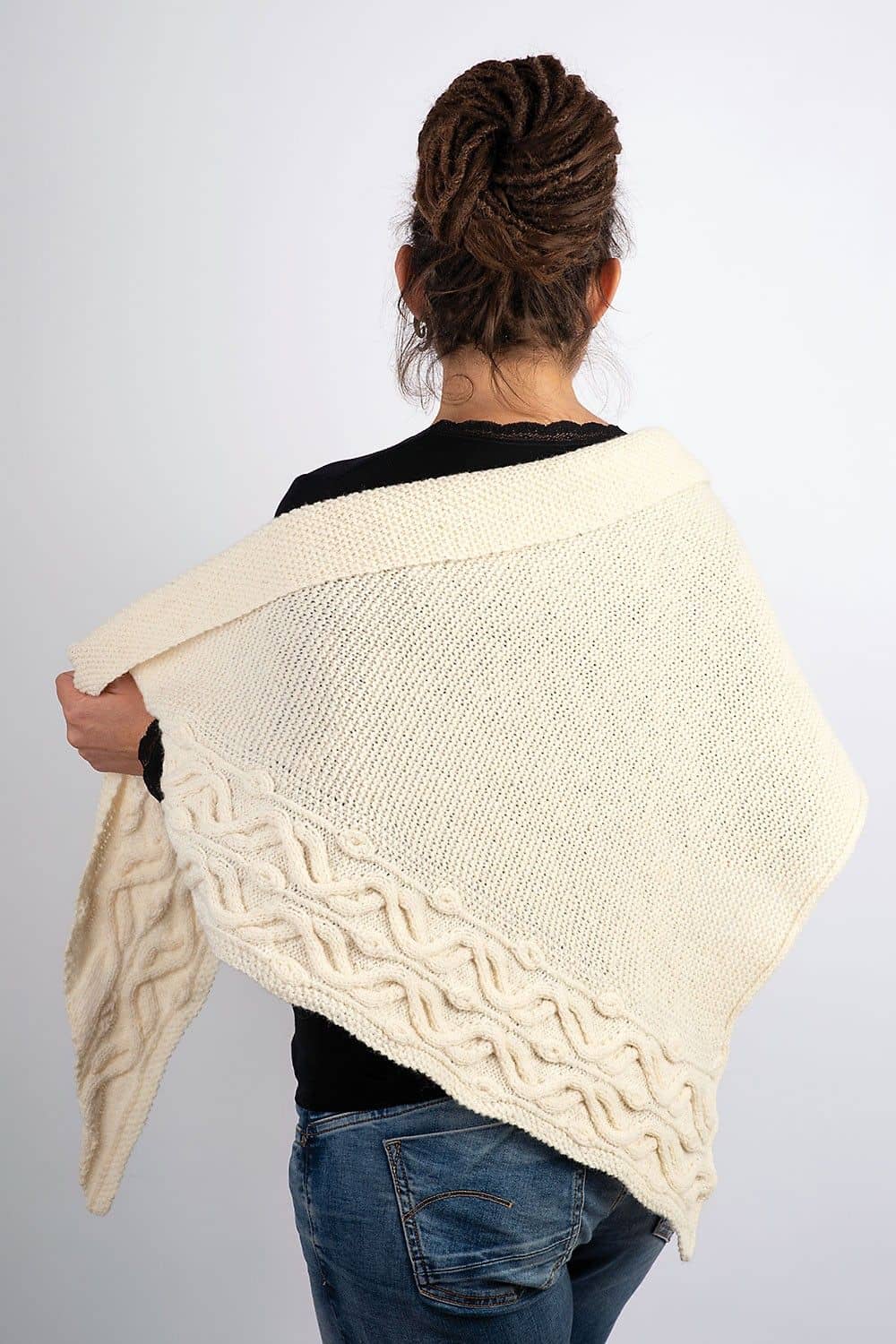 Rückansicht von Frau die sich weißes gestricktes als Beispiel für das Buch ,,Shawls" um die Schultern legt
