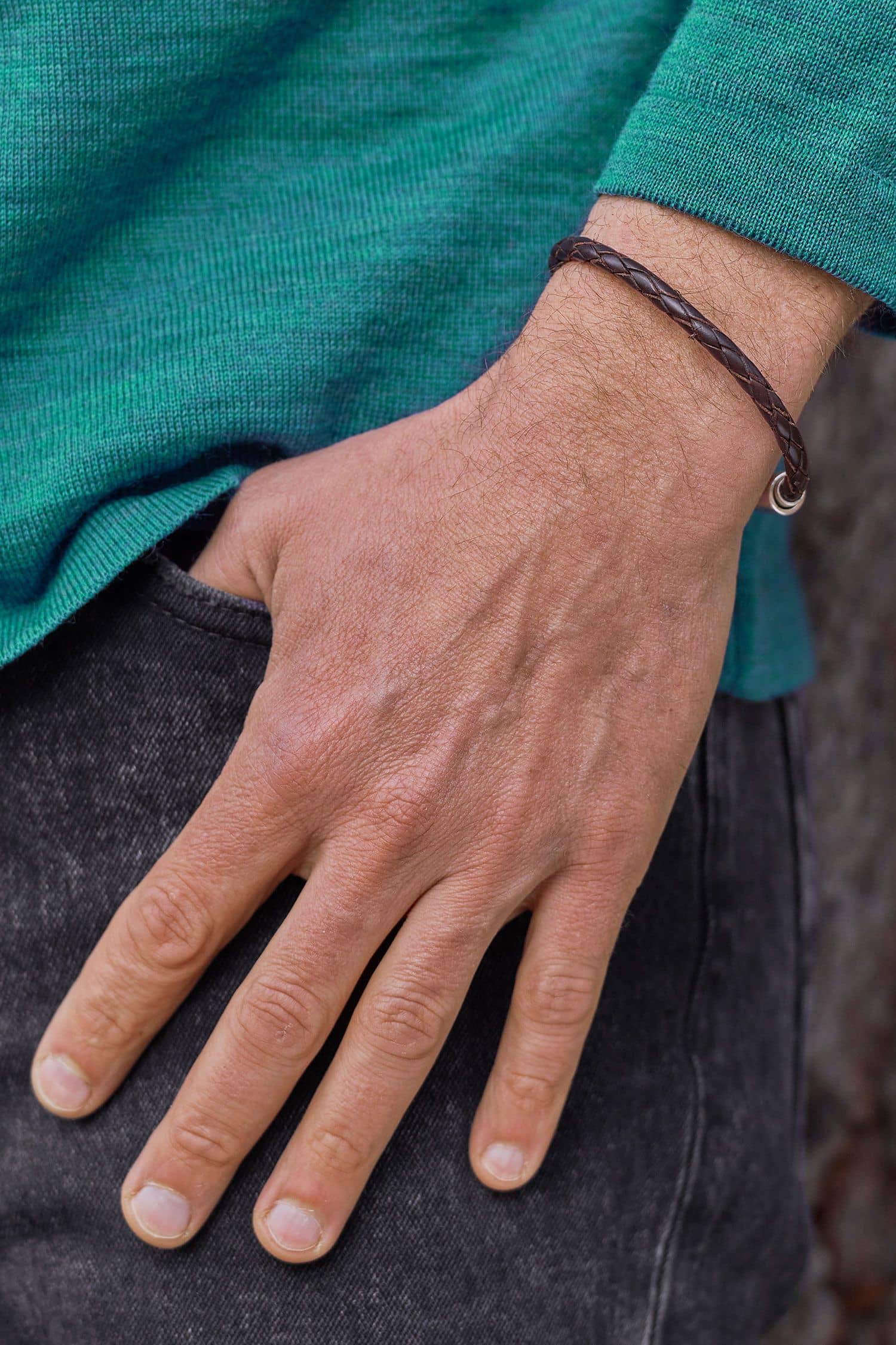 braunes geflochtenes Lederarmarmband aus pflanzlich gegerbtem Leder mit silbernem Verschluss getragen mit türkisem Shirt