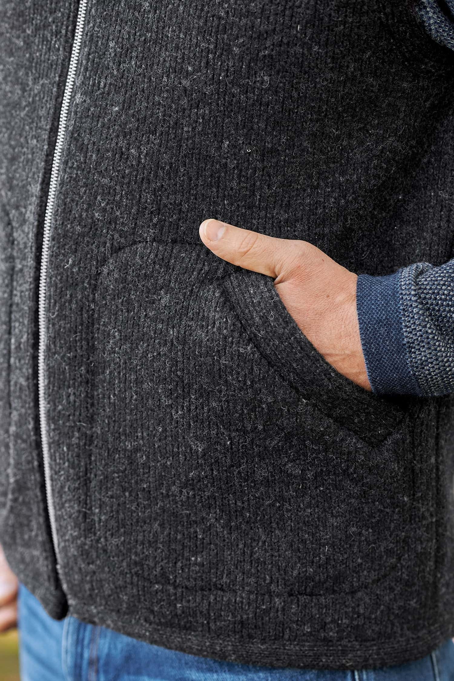 Hände in der Tasche der anthrazitfarbenen Wollwalkweste ohne Ärmel aus bio Wolle (kbT) vom Finkhof