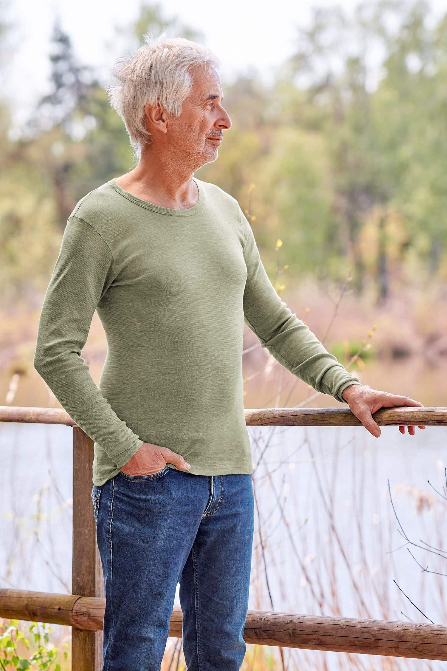 Mann mit Jeans trägt grünes Langarmshirt aus bio Wolle (kbT), bio Baumwolle (kbA) und Seide