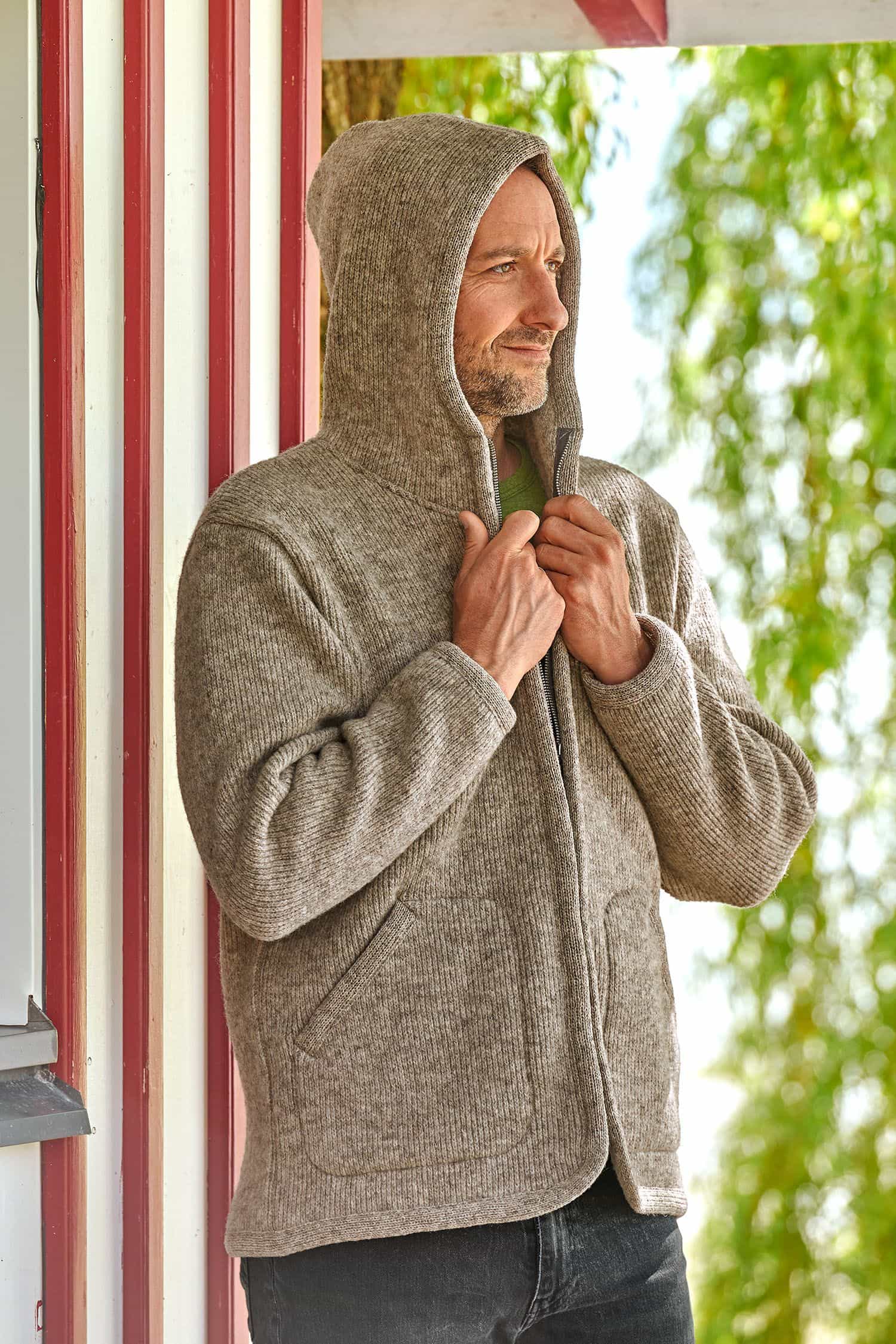Mann trägt die Kapuze der grauen Finkhof Jacke aus bio Wolle (kbT)