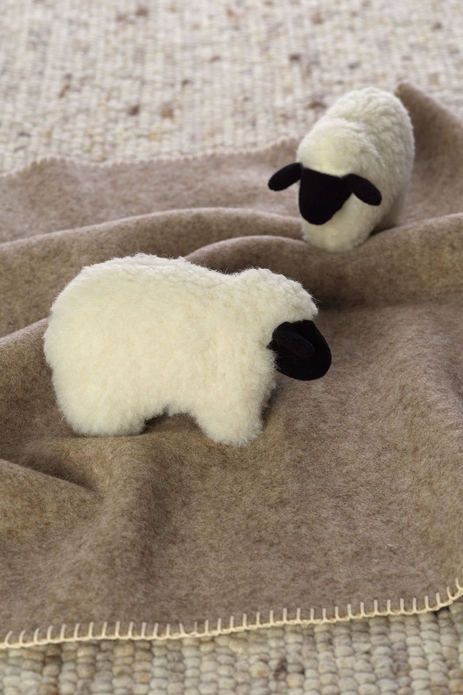 Rasselschaf Rasselschaf aus Wolle auf brauner Decke