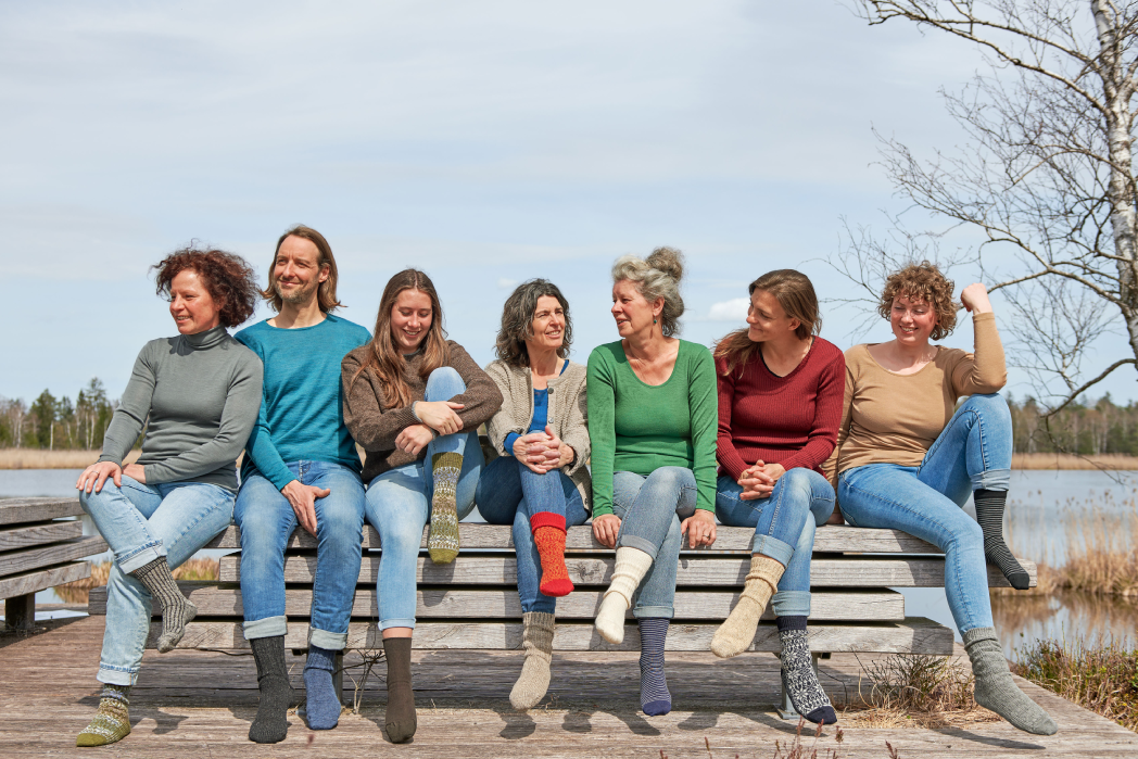 Finkhof Models auf einer Bank mit vielen bunten Socken an den Füßen