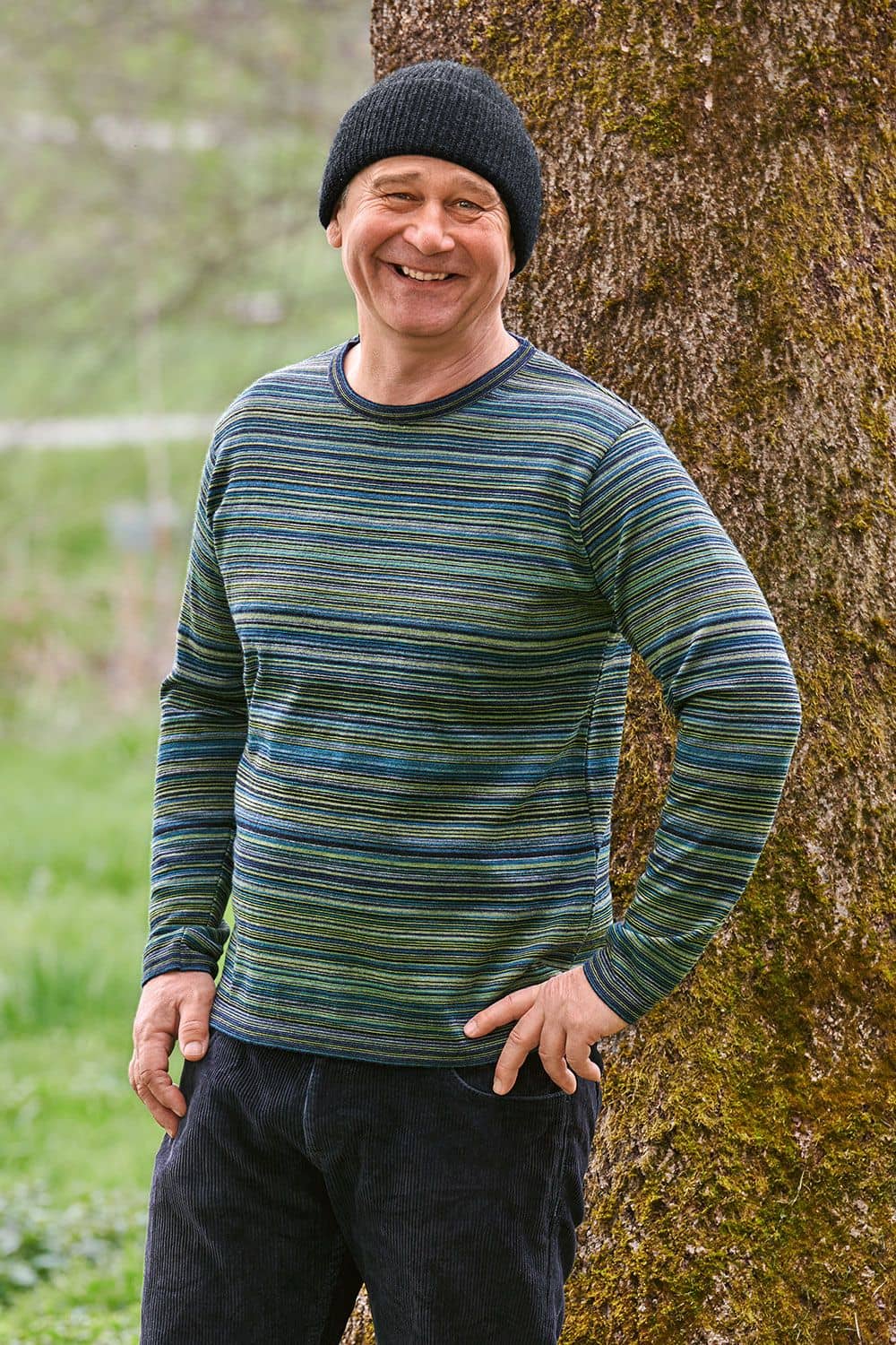 Mann mit dunkelgrauer Mütze trägt ein Shirt mit kleinen Streifen in blau und grün aus bio Wolle (kbT) vom Finkhof