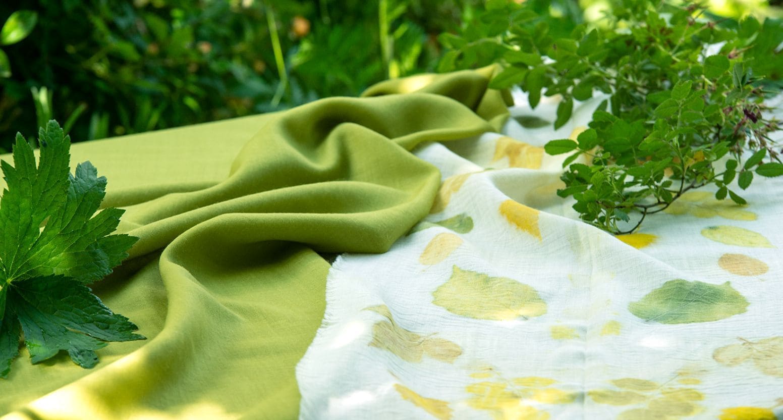weißer Stoff mit grünem Blättermuster und grünem Stoff daneben