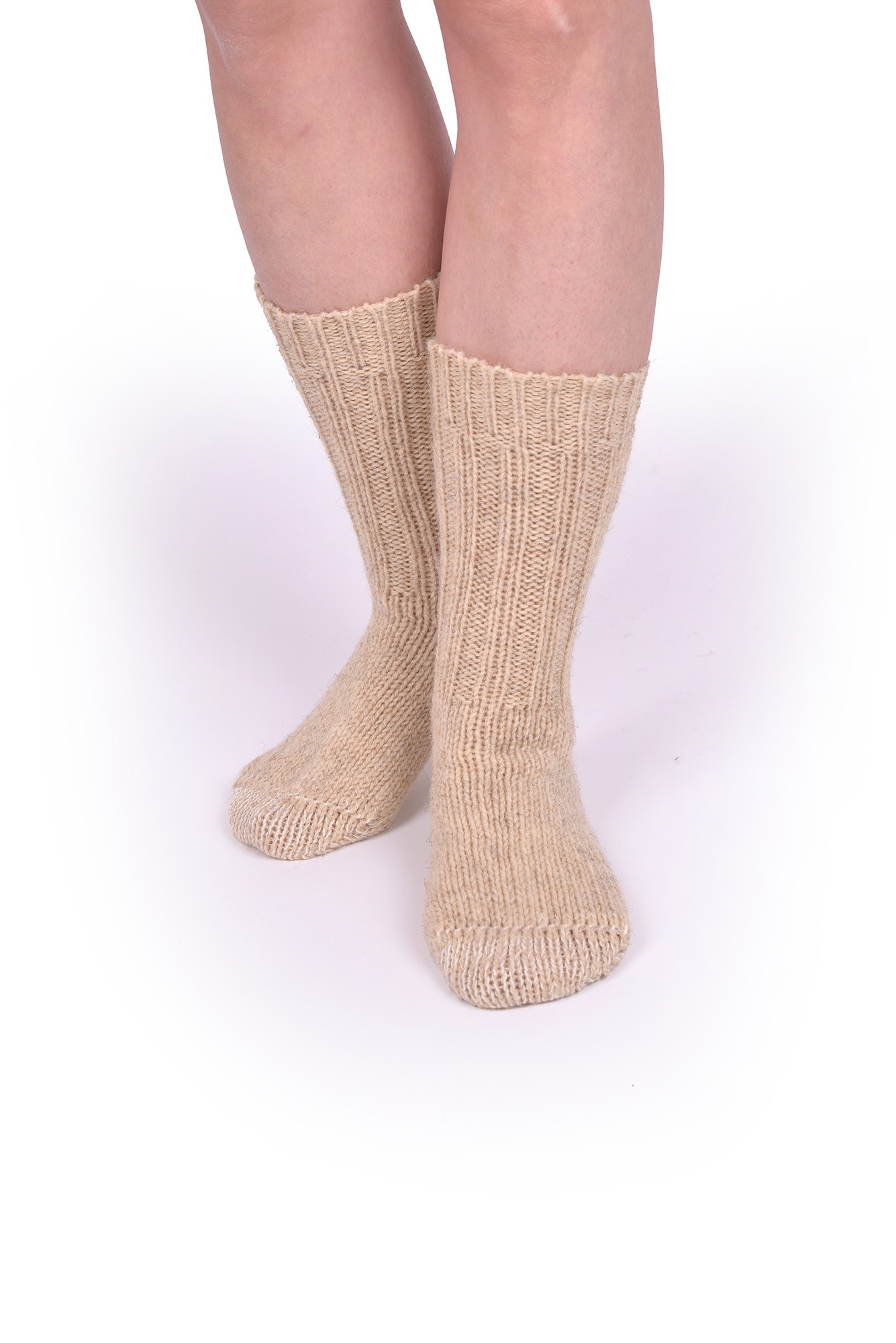Dicke Finkhof-Socken aus reiner Bio-Schurwolle Person trägt beige dicke Finkhof Socken aus bio Wolle (kbT) auf weißem Untergrund