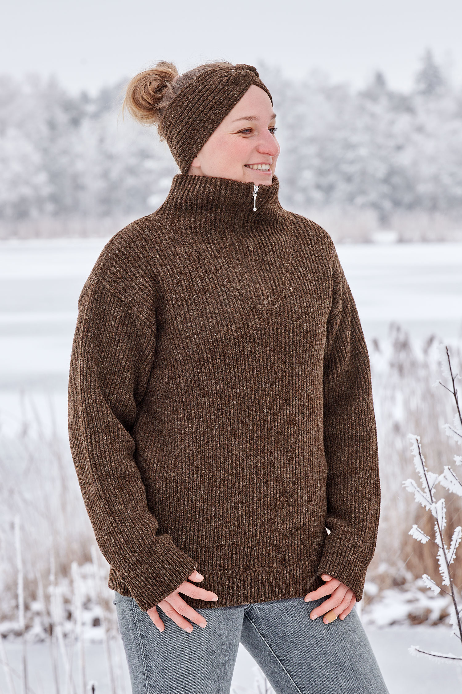 Frau in Schneelandschaft trägt Stirnband mit Twist und braunen Finkhof Troyern in braun aus bio Wolle (kbT)