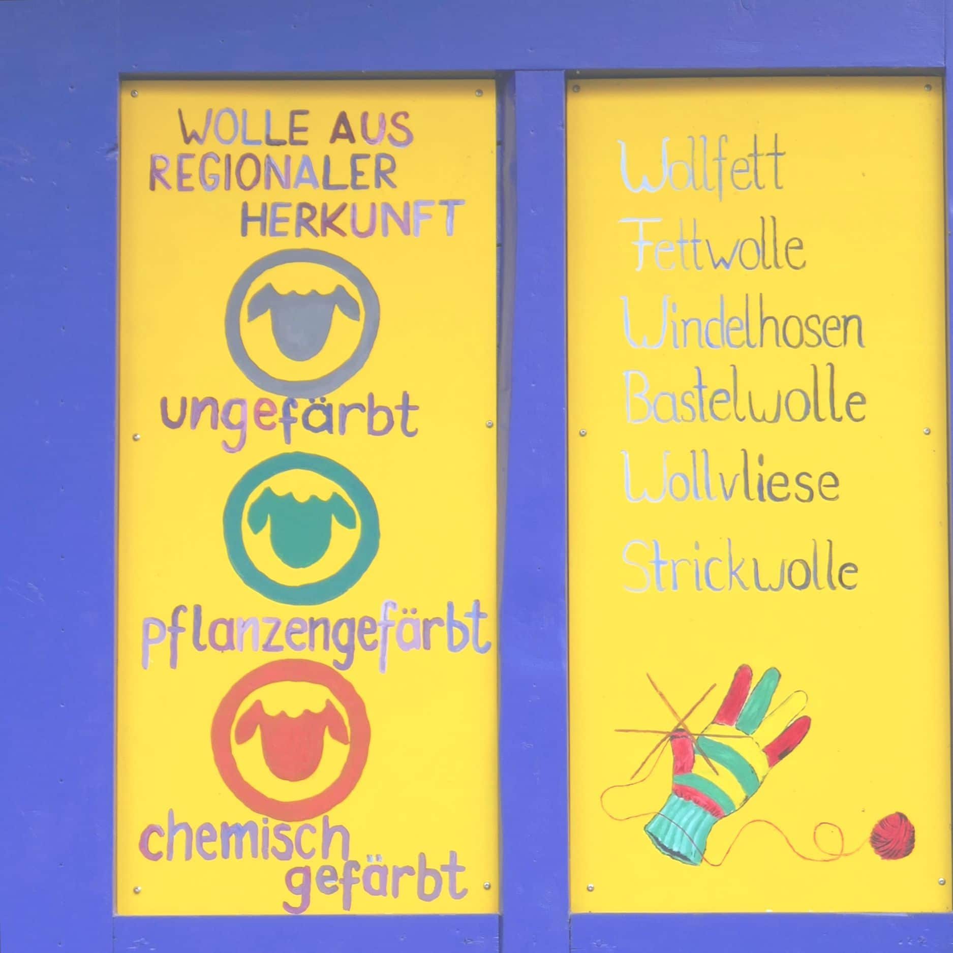 Finkhof Ladentür in gelb und blau mit Schafkopfsymbolen