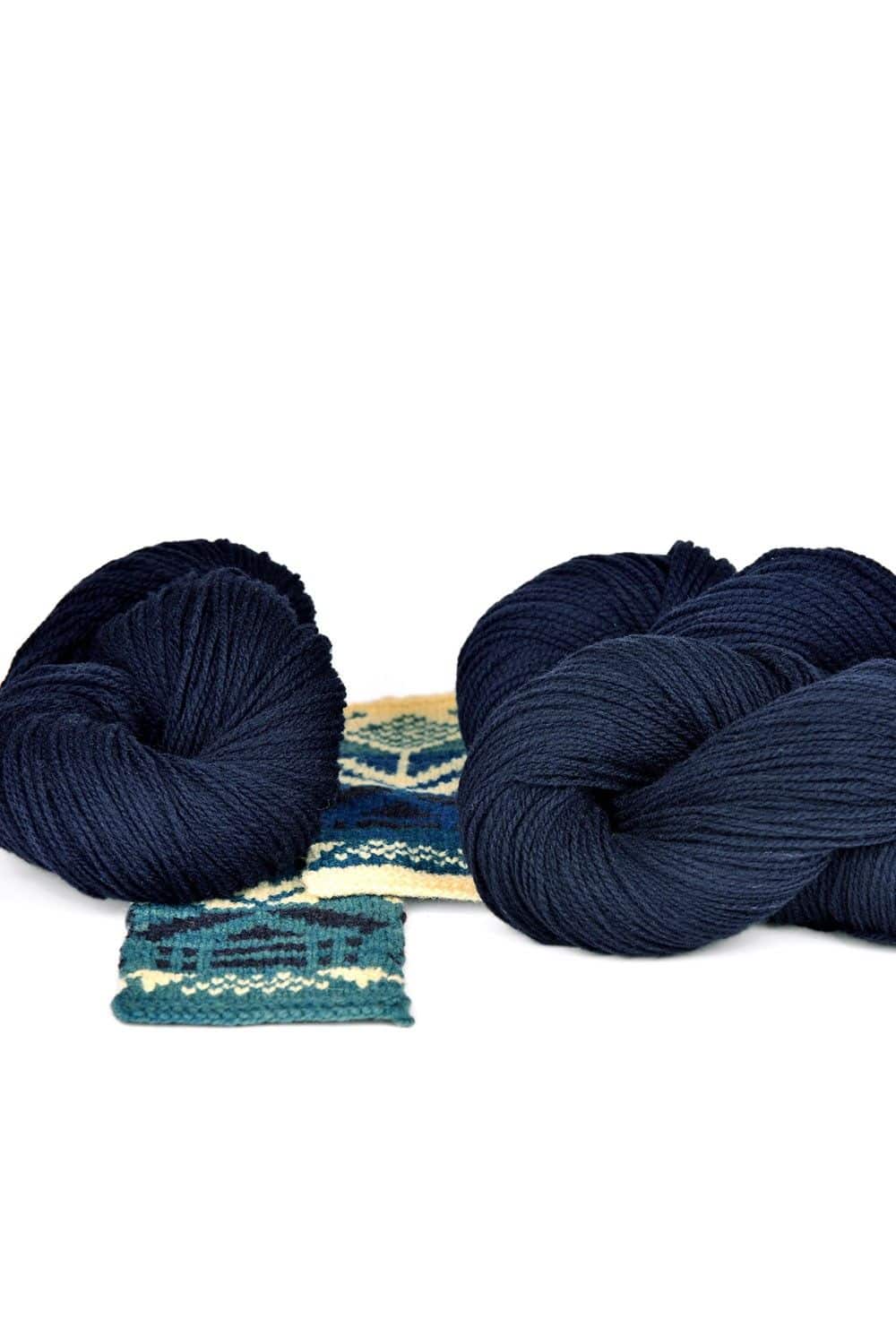 dicke marineblaue Finkhof Merinowolle aus bio Wolle (kbT) mit Strickstück davor, weißer Untergrund