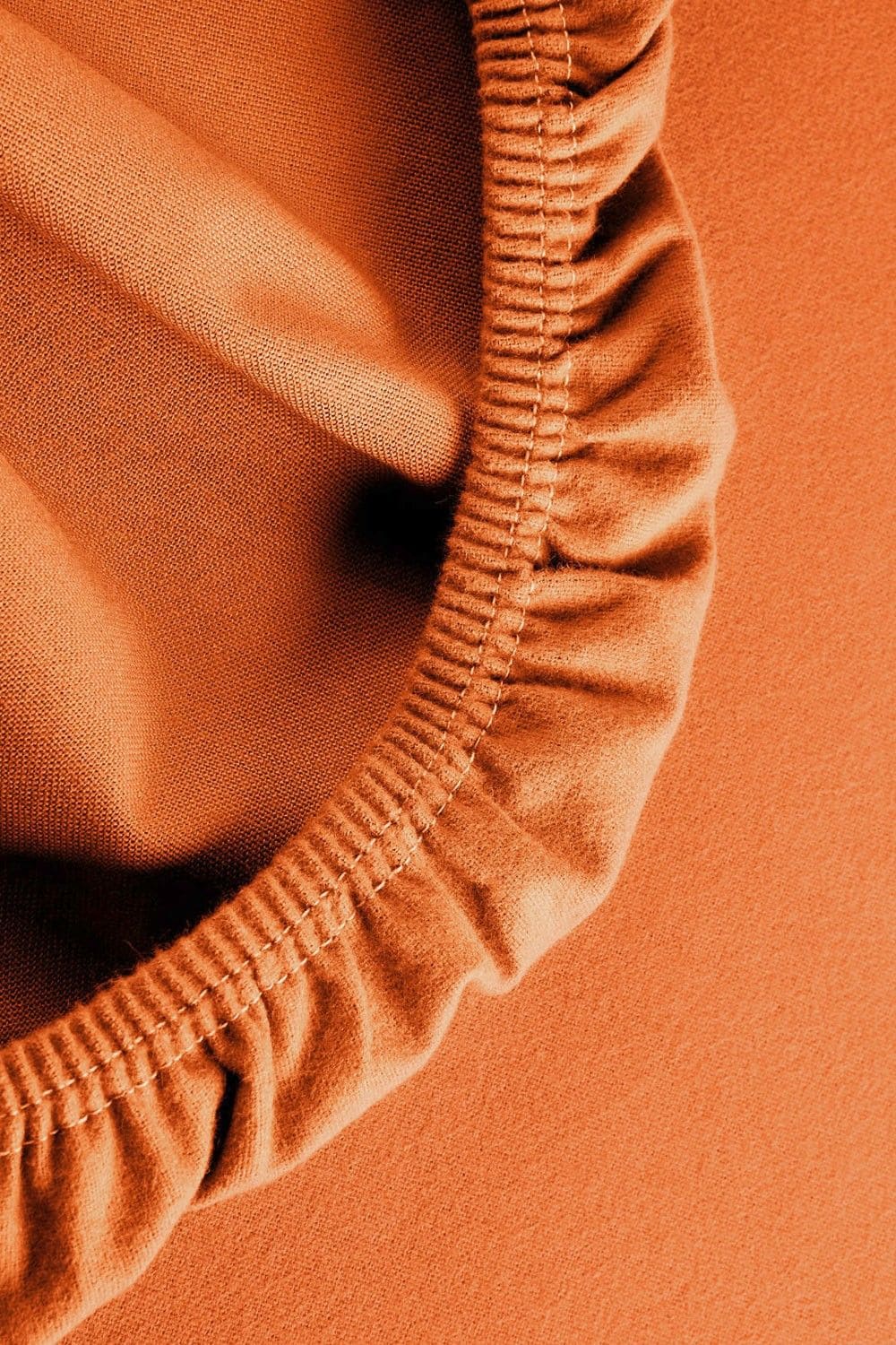 Detailaufnahme vom Gummizug des orangen Biber Spannbettlaken aus bio Baumwolle (kbA)