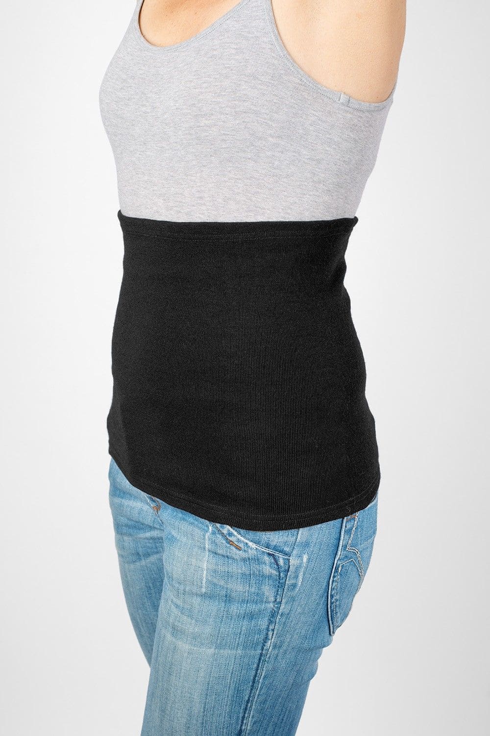Model trägt Jeans, graues Top und leichten schwarzen Nierenwärmer aus bio Wolle (kbT), Seide, Baumwolle und Elasthan