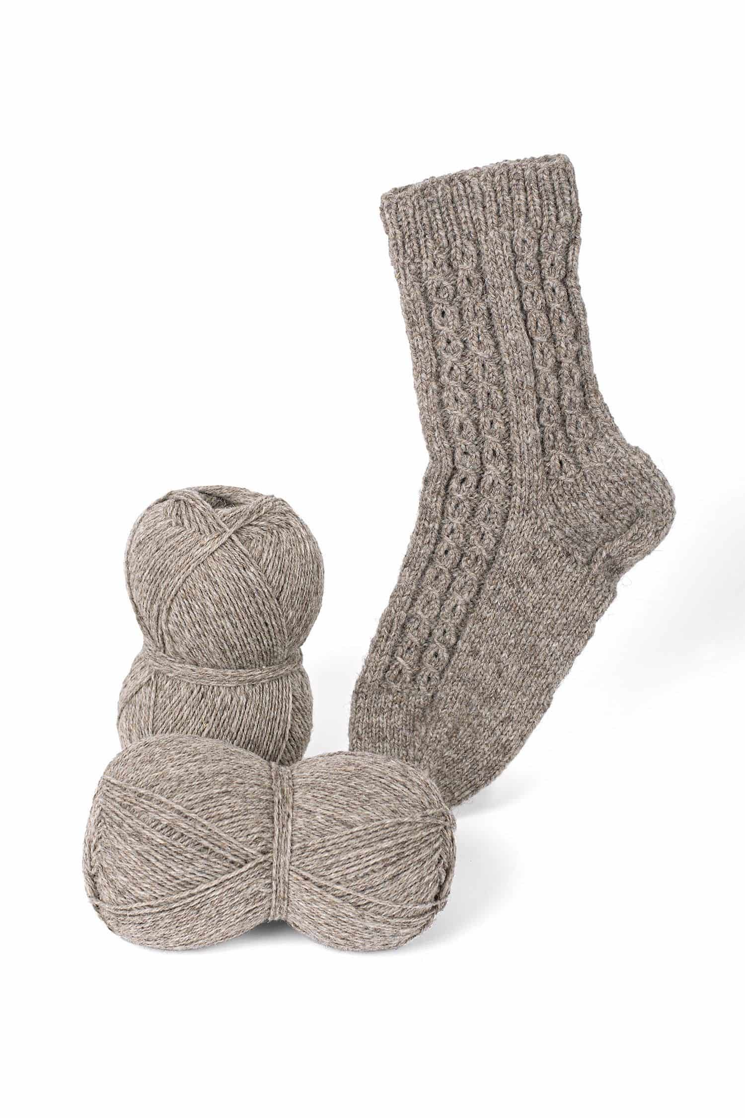 graue Finkhof Sockenwolle aus bio Wolle (kbT) mit Knäulen und fertiger Stricksocke