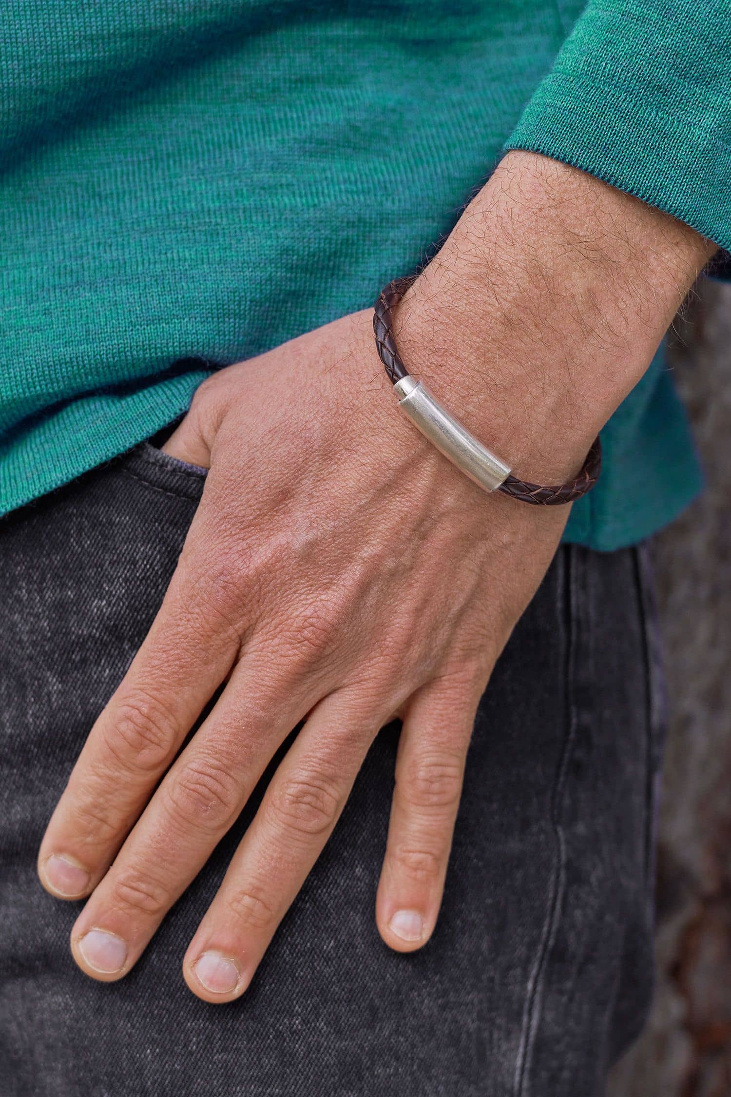 braunes Flecht-Lederarmband mit silbernem Verschluss aus pflanzlich gegerbtem Rindsleder mit türkisem Pulli und Jeans