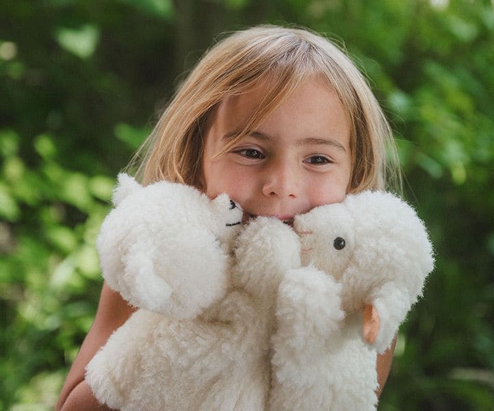 Kind umarmt zwei Kuscheltiere