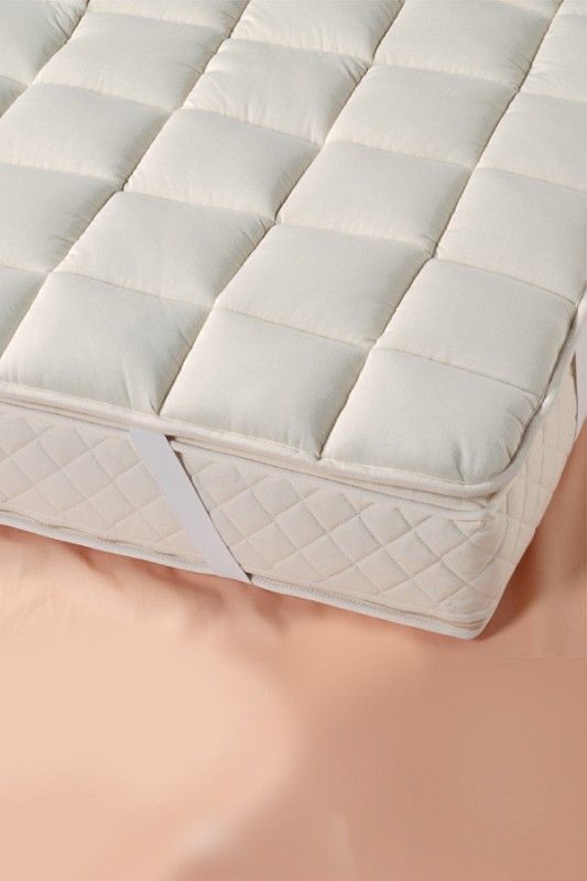 Ecke einer Matratze auf der das dicke Wollunterbett vom Finkhof aus bio Wolle (kbT) und bio Baumwolle (kbA) mit 90x200cm liegt