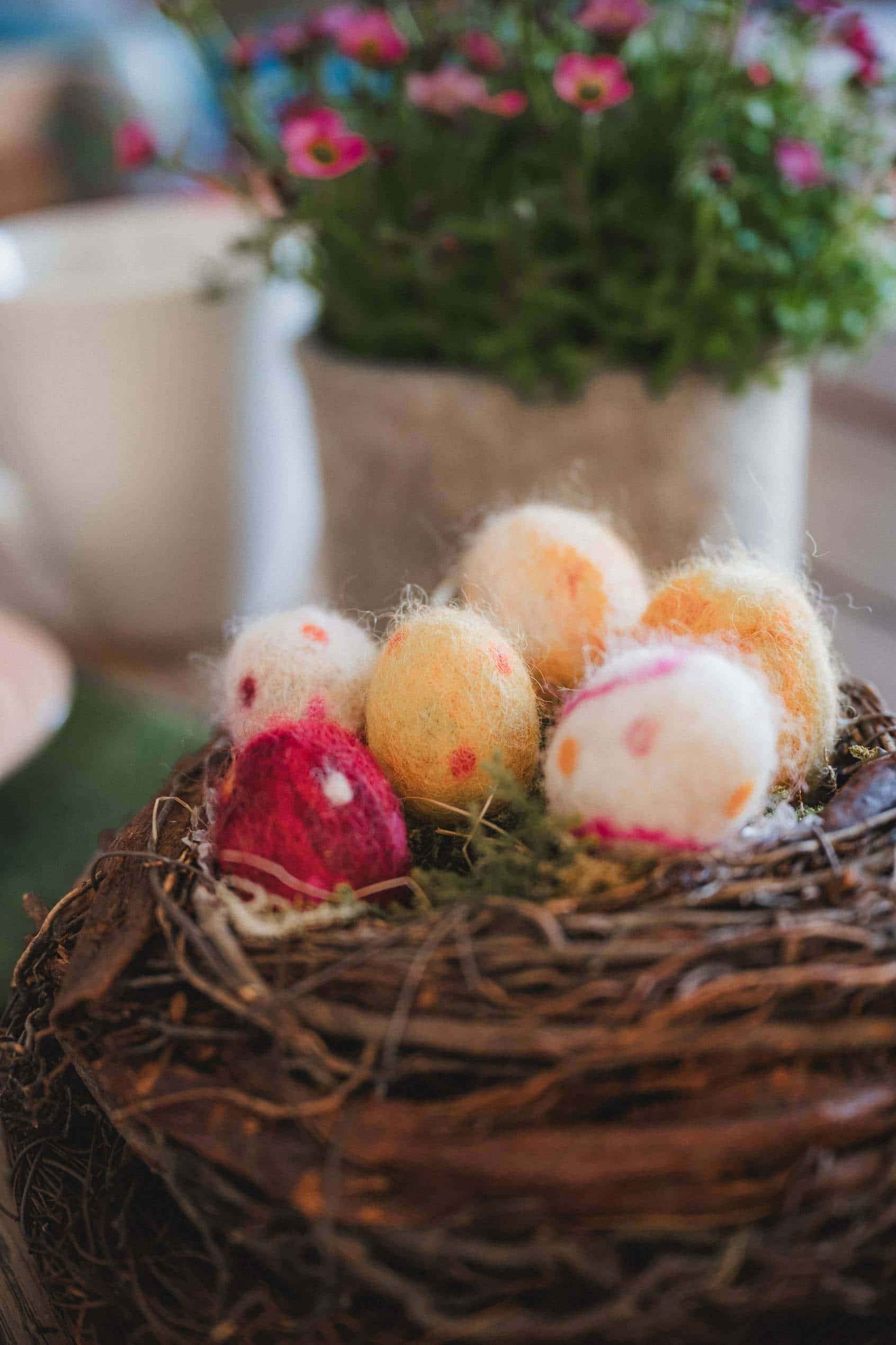 Osternest aus Naturmaterialien mit bunten Filzostereiern