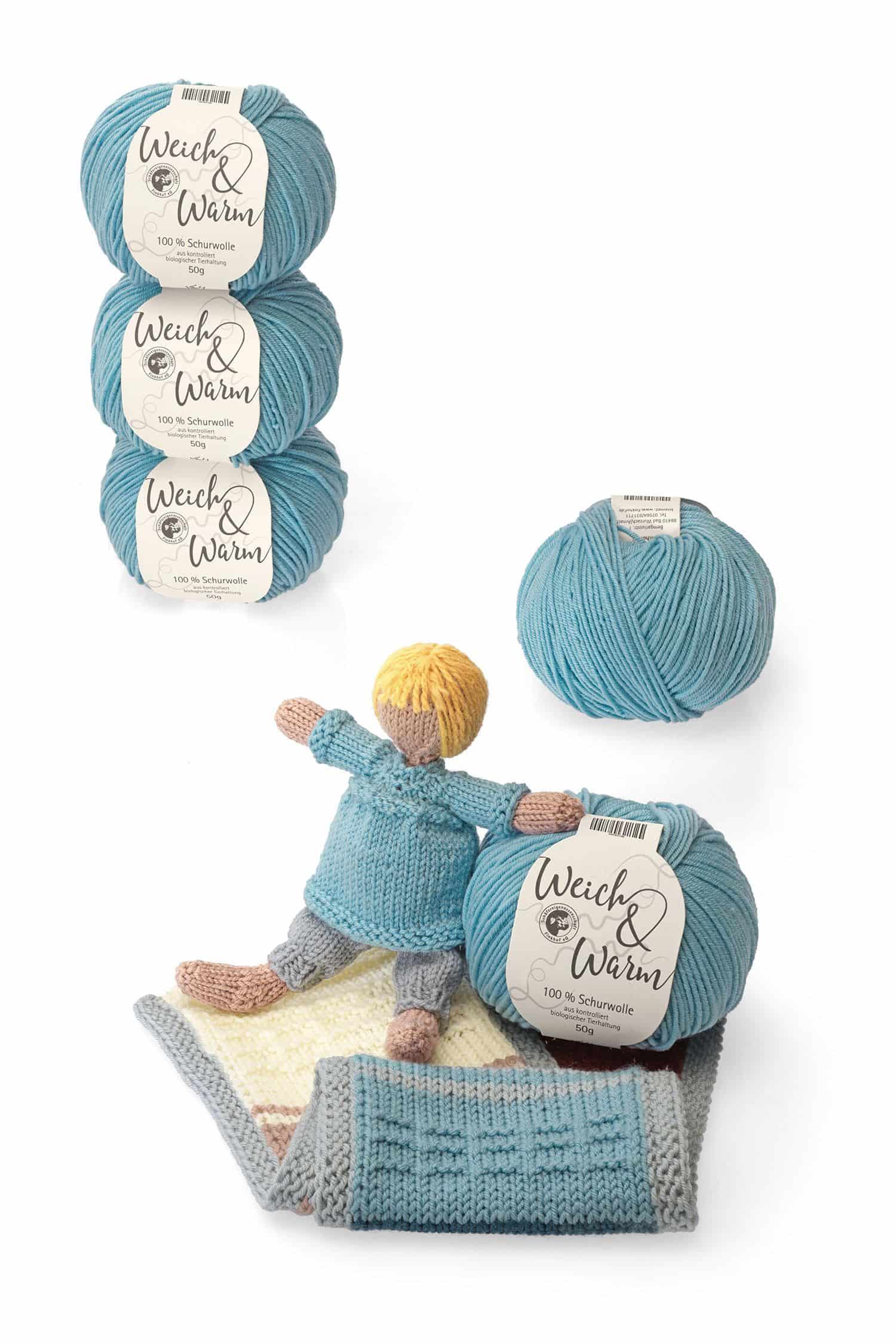 Finkhof Merinowolle Weich&Warm in hellblau aus bio Wolle (kbT) als Knäule mit Puppe und Decke daneben