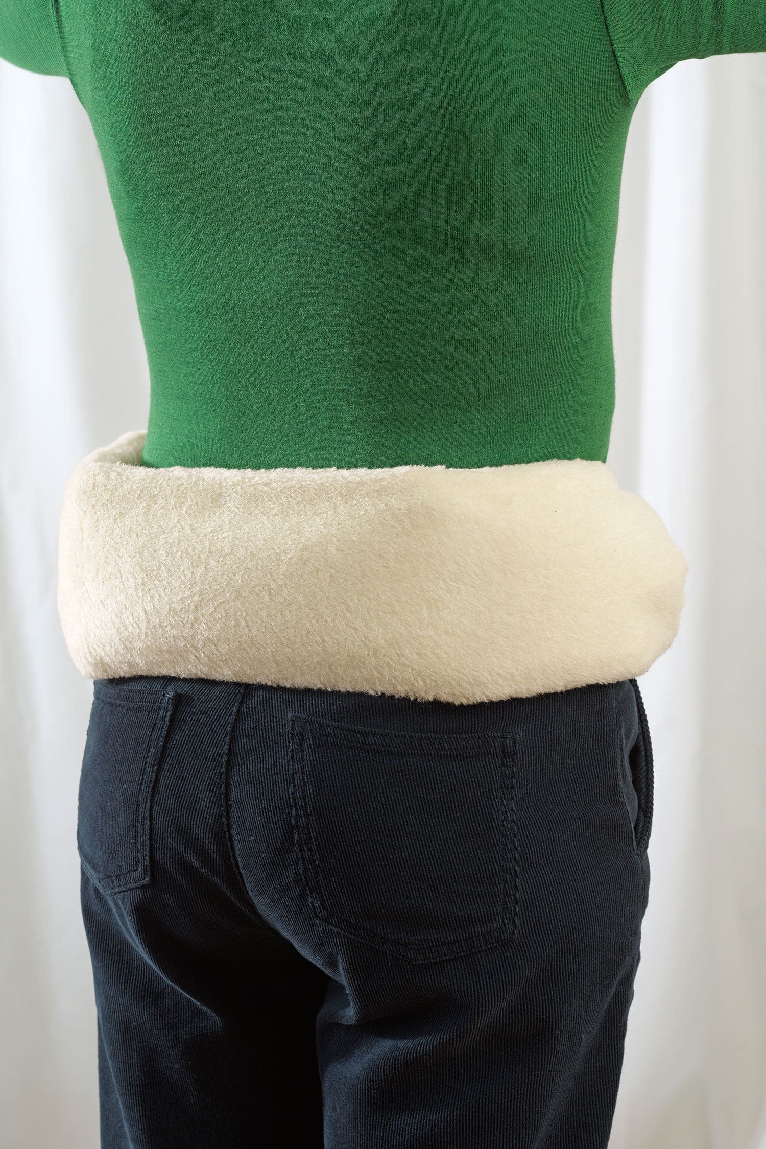 Frau hat sich lange Wärmflasche mit Lammflorbezug aus Wolle und bio Baumwolle (kbA) vom Finkhof an Rücken geschnallt