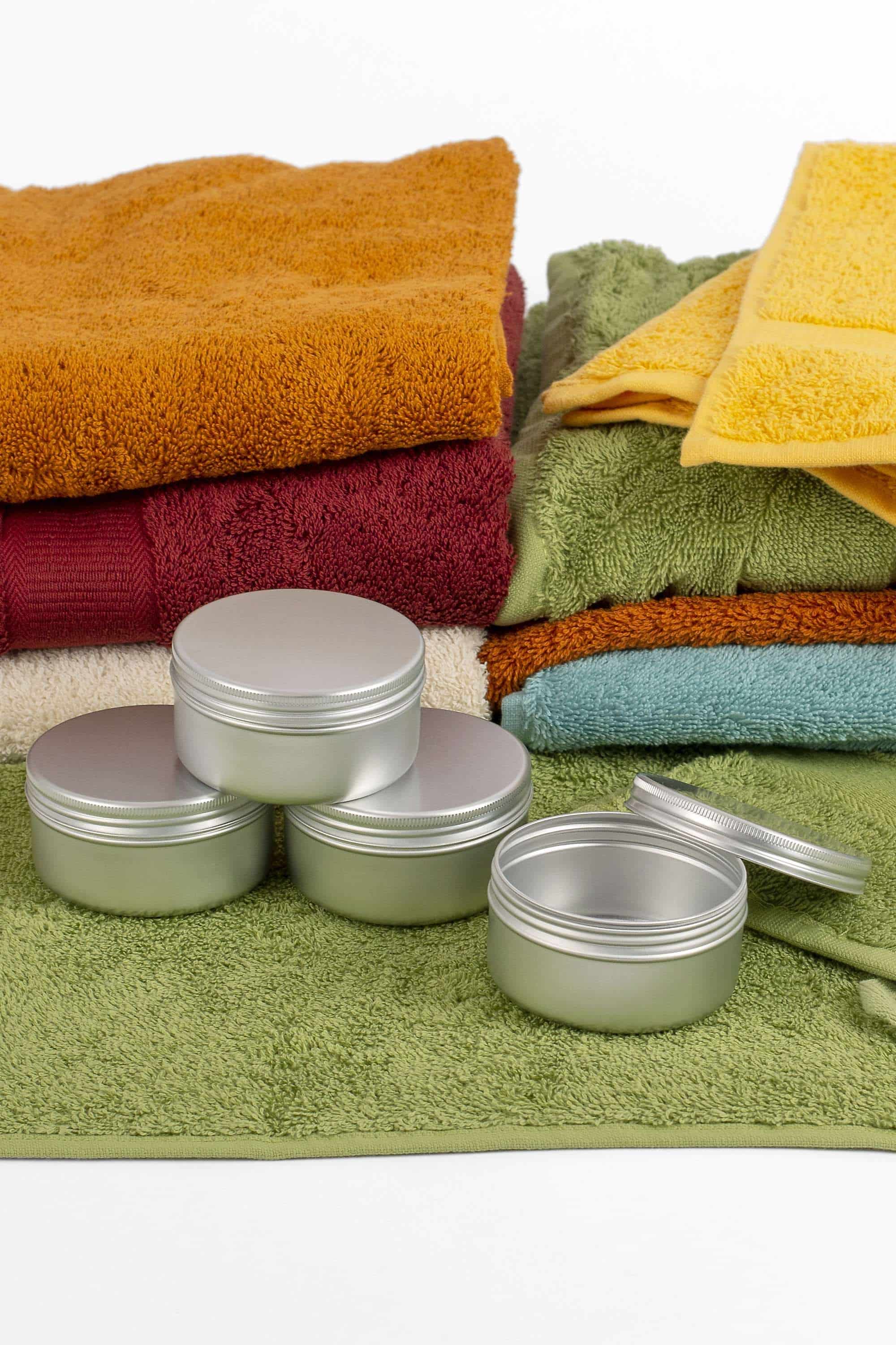 Alu-Schraubdose Alu-Schraubdose für festes Shampoo oder Seife, auf bunten Handtüchern gezeigt