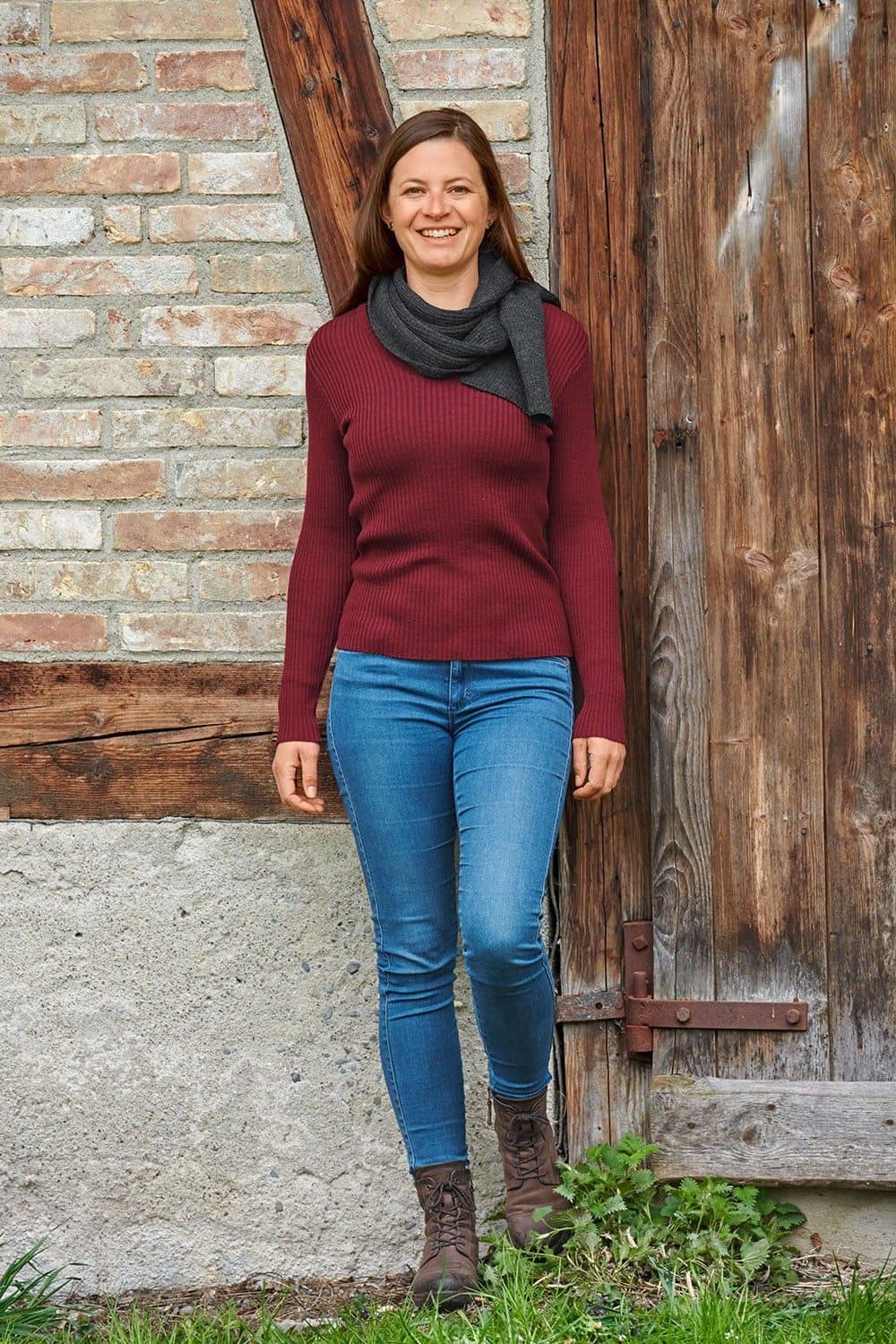 Frau mit rotem Shirt trägt einen anhrazitgrauen Schal aus bio Wolle (kbT) vom Finkhof