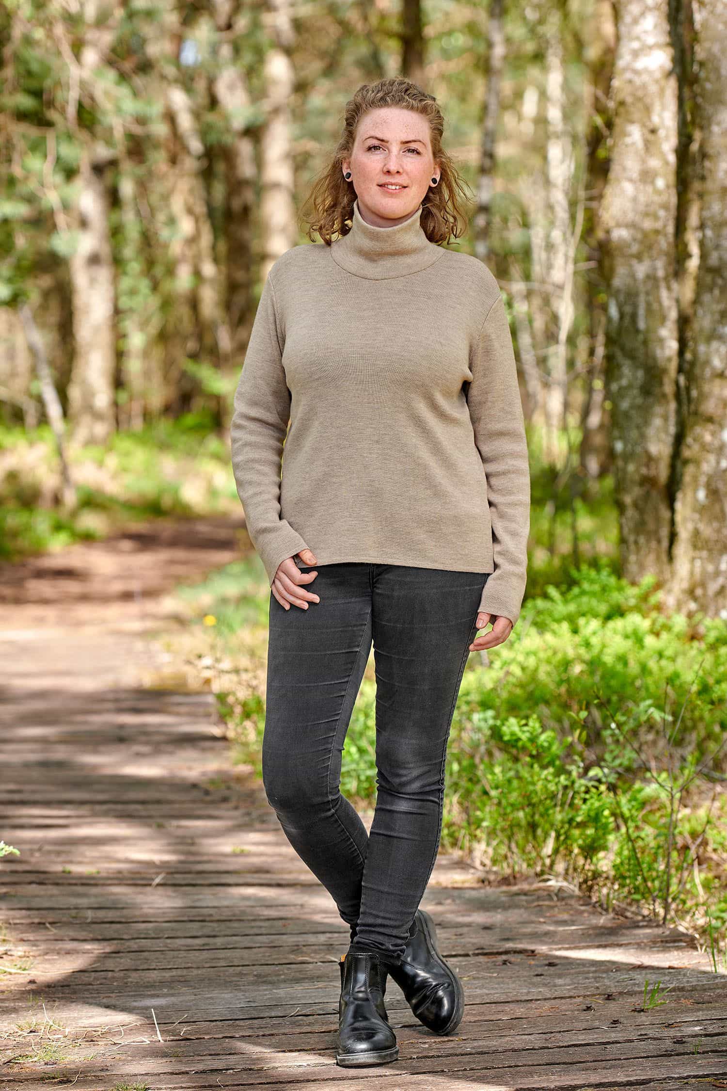 Damen-Rollkragenpullover aus Bio-Merinowolle Frau trägt braunen Pullover mit Rollkragen aus bio Merinowolle (kbT) vom Finkhof und eine schwarze Jeans