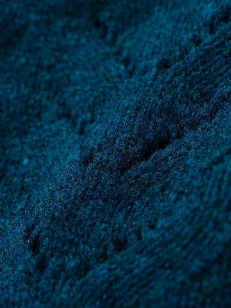 Nahaufnahme der Struktur des seeblauen Strickpullunder mit Ajourmuster vom Finkhof