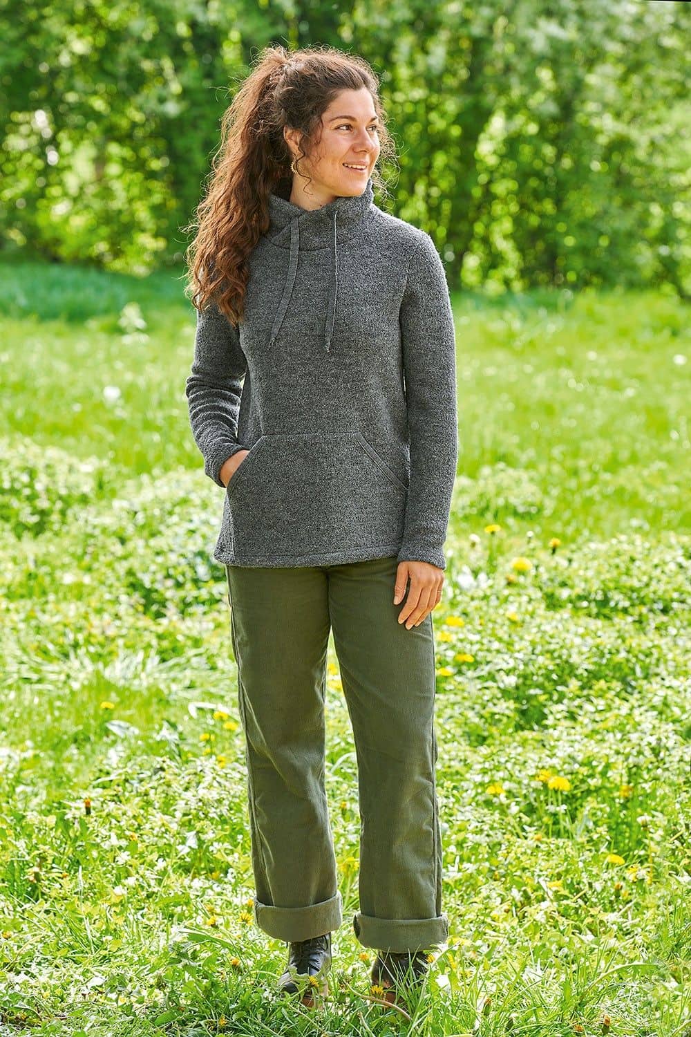 Frau trägt grüne Hose und grauen Pulli aus bio Wolle (kbT)