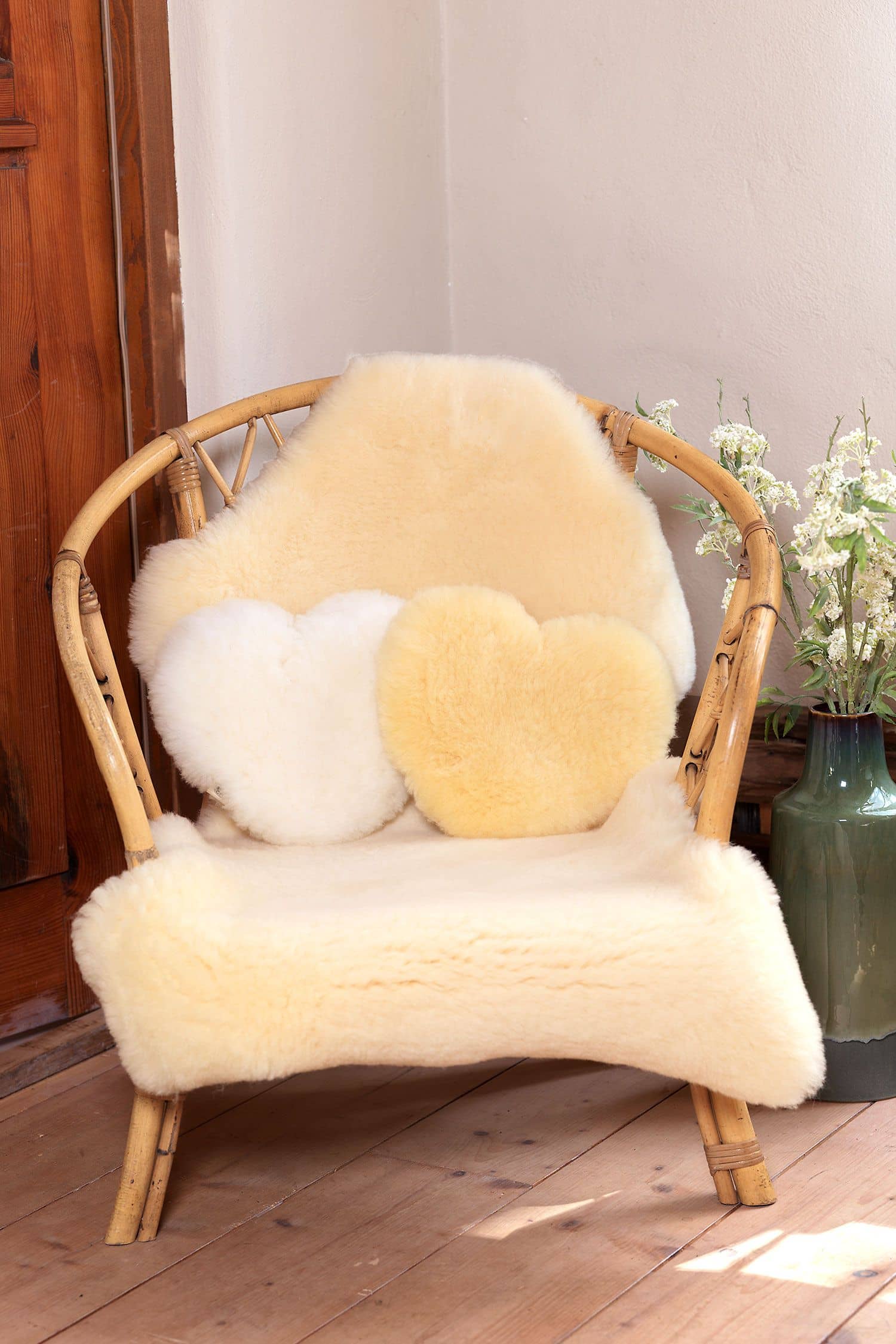 Herzkissen Korbstuhl mit Fellen und Herzkissen aus Schaffell vom Finkhof