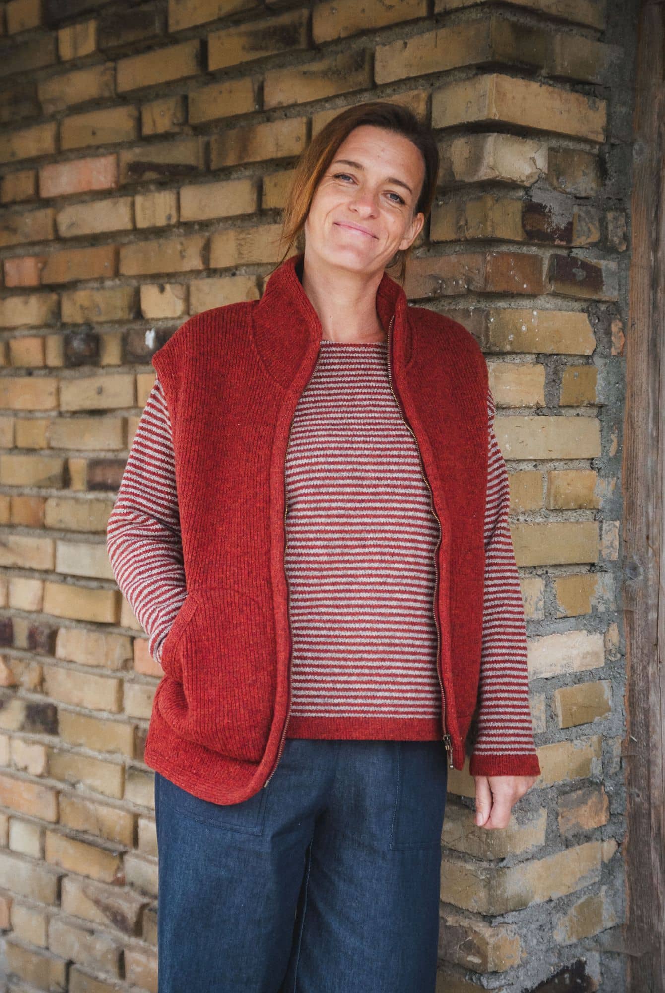 Frau mit rotem Streifenpulli trägt eine rote Wollwalkweste ohne Ärmel aus bio Wolle (kbT) vom Finkhof