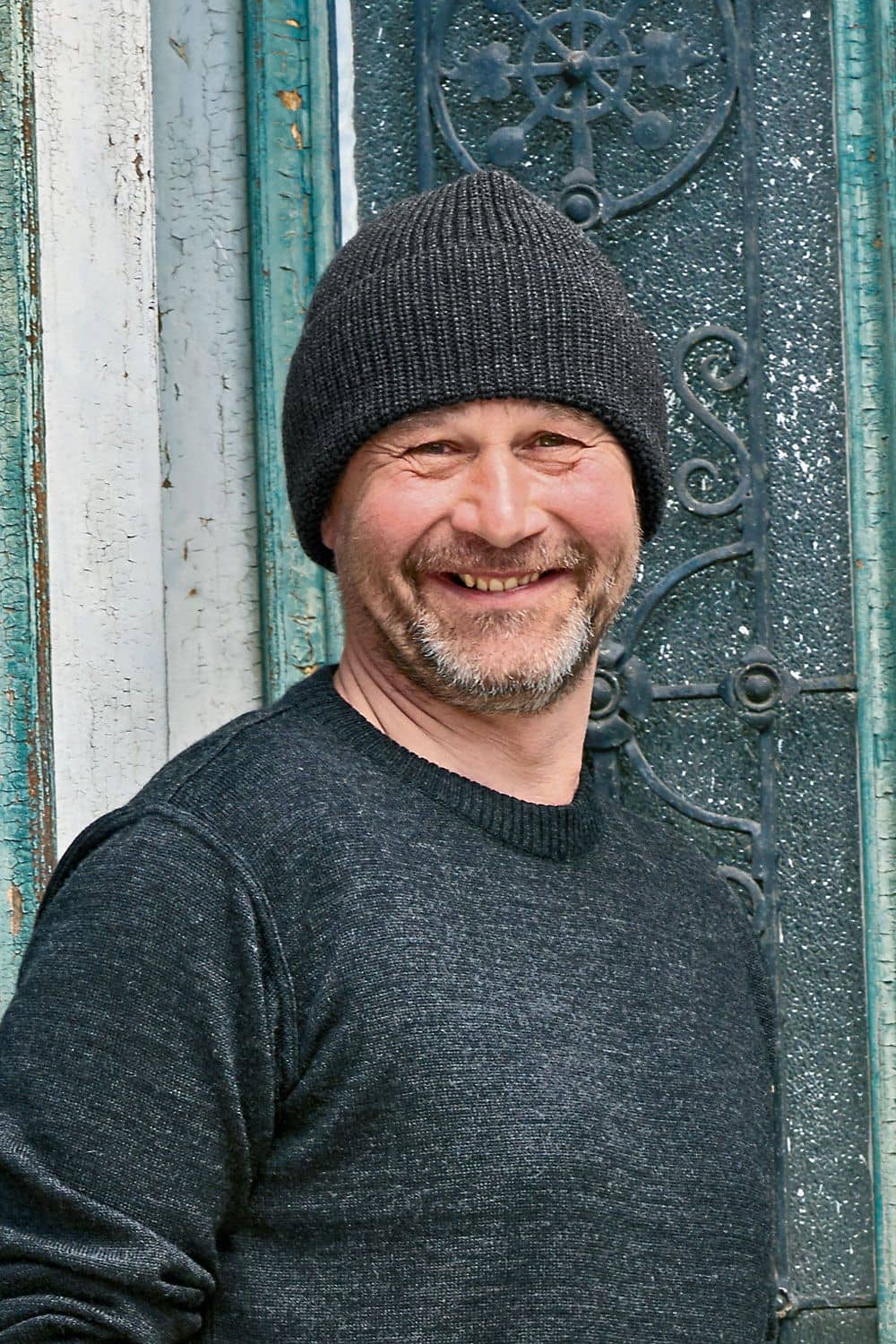 Wollmütze aus reiner Bio-Schurwolle Mann trägt einen dunkelgrauen Pullover und eine anthrazitgraue Wollmütze aus bio Wolle (kbT) vom Finkhof