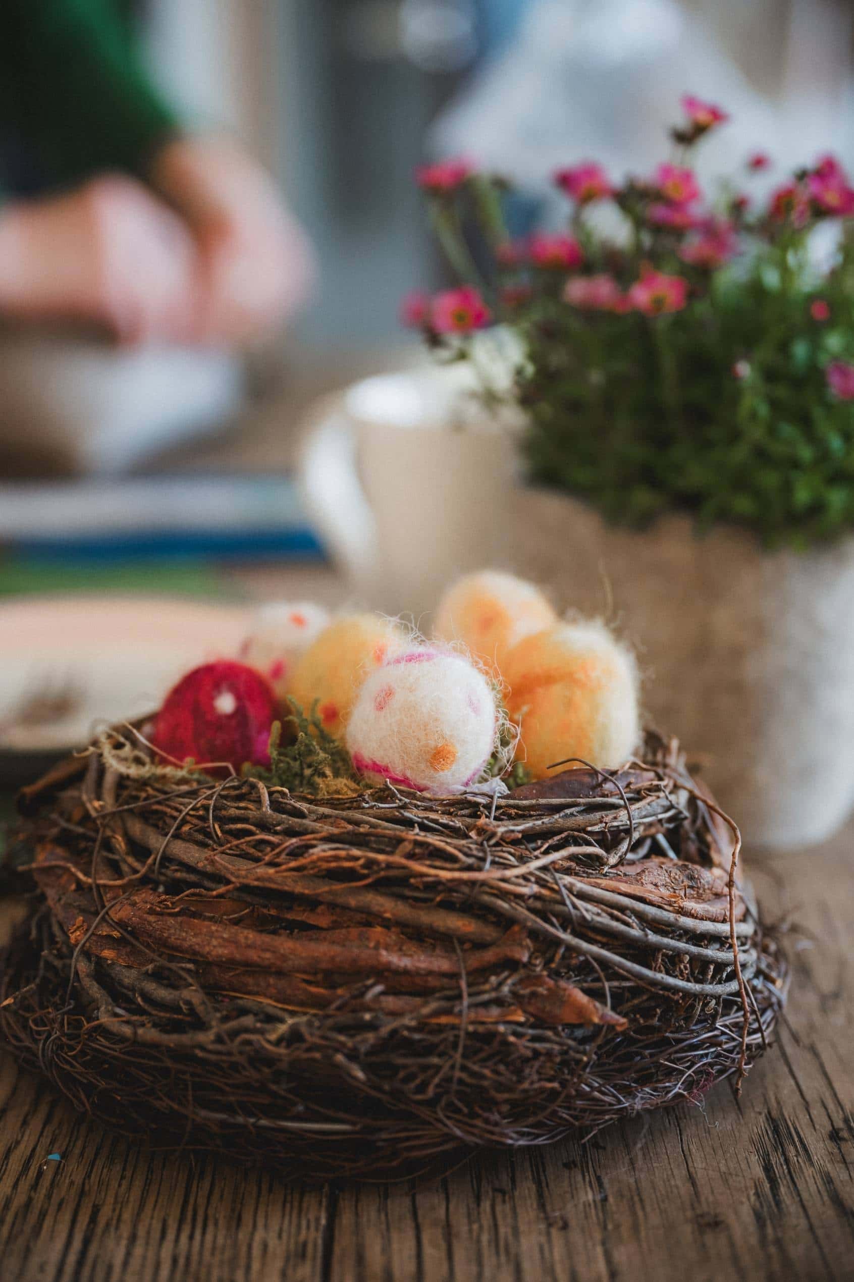 Osternest aus Naturmaterialien mit bunten Filzostereiern
