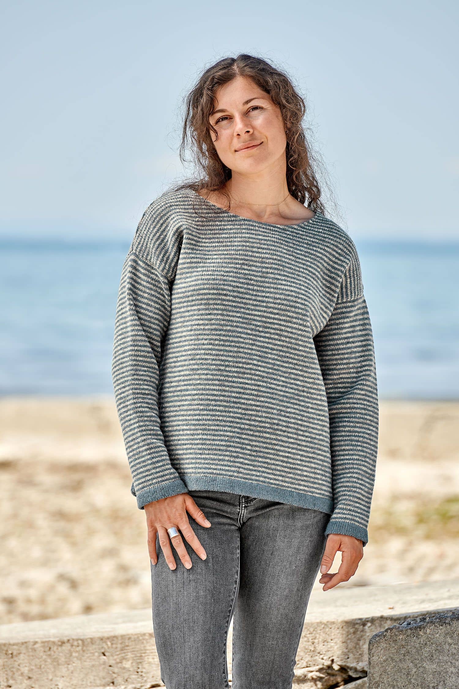 Frau trägt einen grau blauen Ringelpulli vom Finkhof aus bio Merinowolle (kbT)