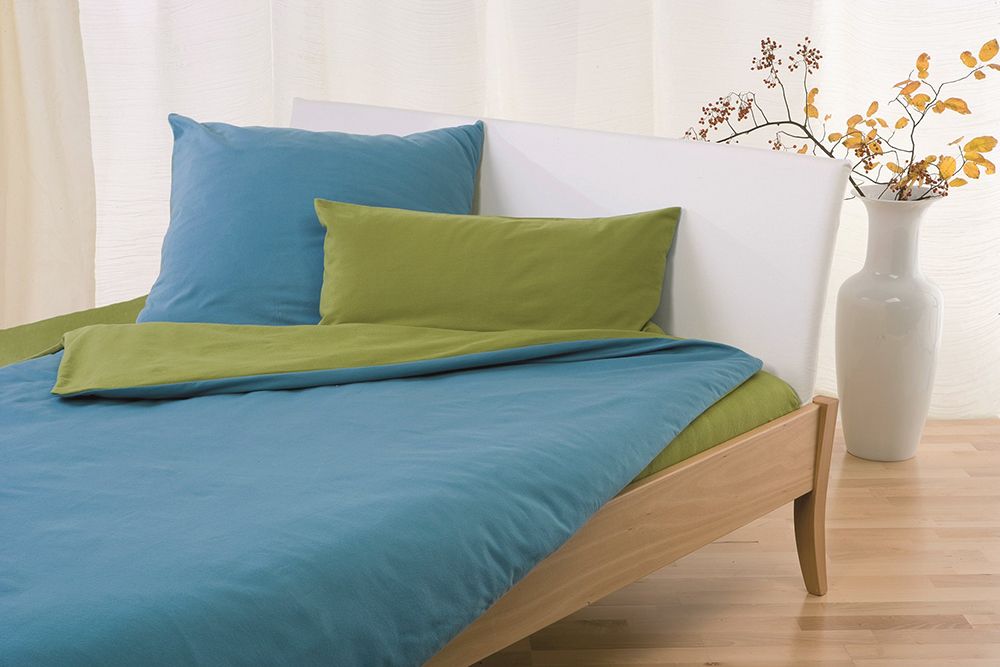 grün türkise Biberbettwäsche zum Wenden aus bio Baumwolle (kbA) in weißem Bett und Vase im Hintergrund