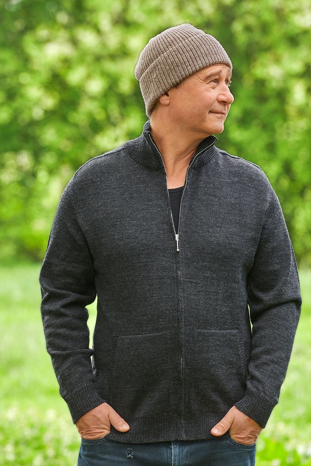 Mann mit anthraziter Strickjacke trägt graue Finkhof Mütze aus bio Wolle (kbT)