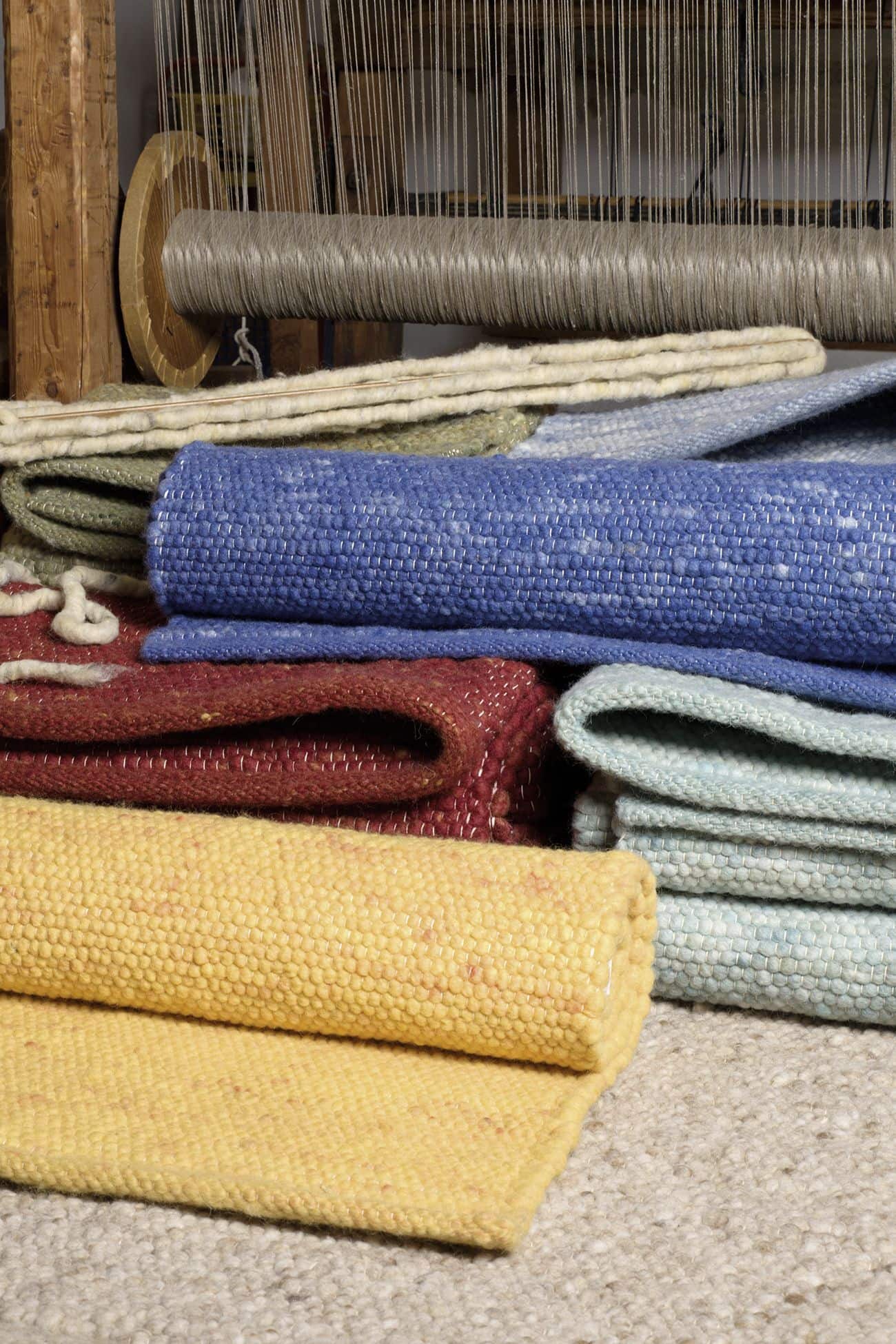 Finkhof Teppiche in verschiedenen Farben mit Webstuhl im Hintergrund