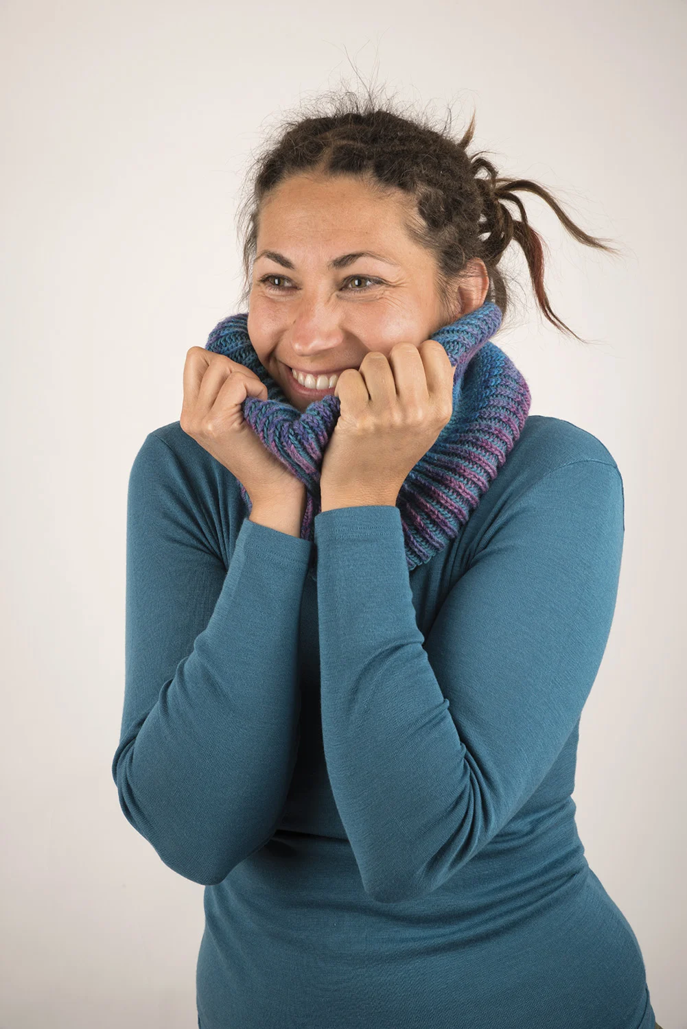 Frau in blauem Shirt trägt blau lila Loopschal
